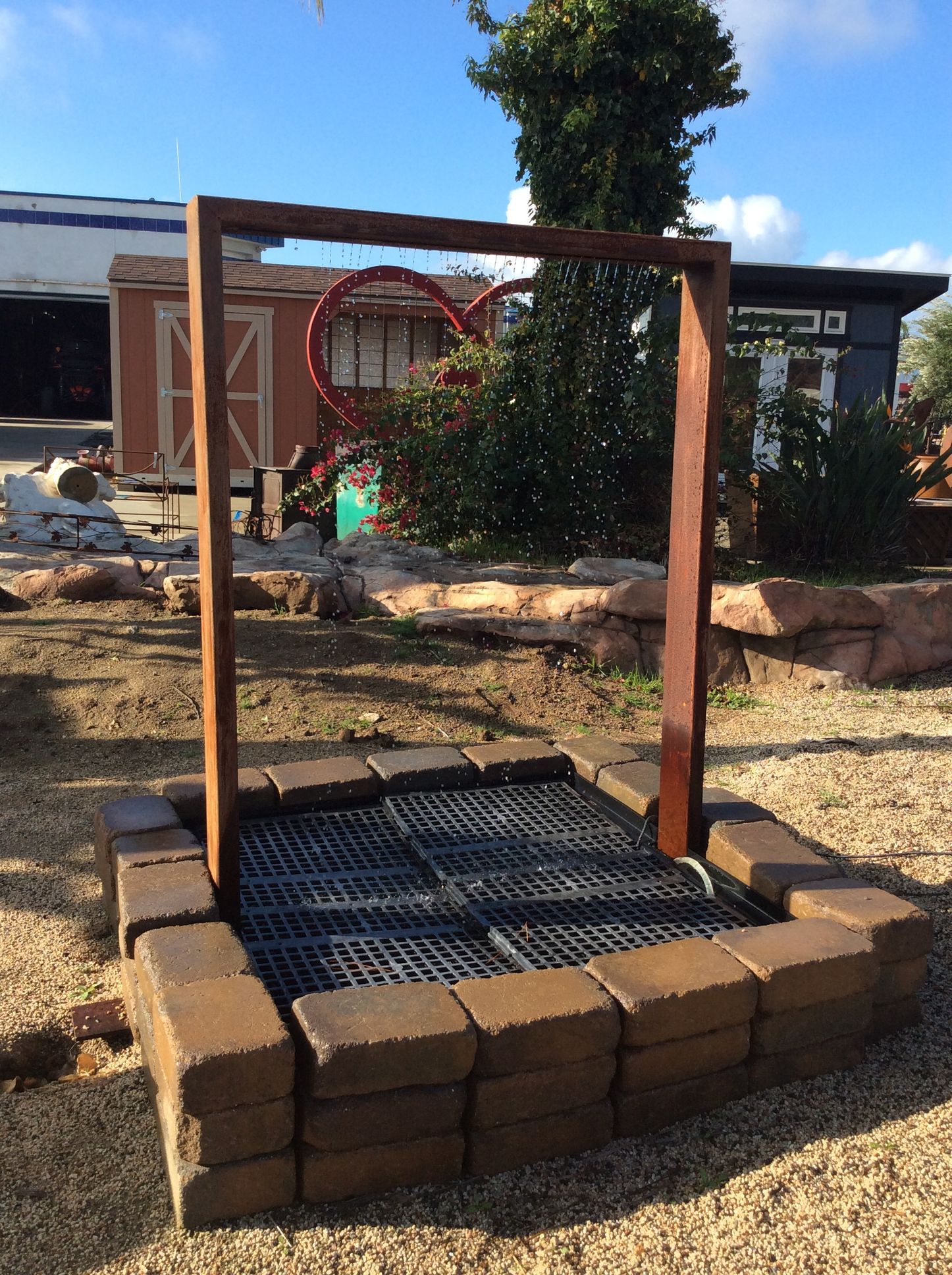 A wooden frame with a heart on it is surrounded by bricks