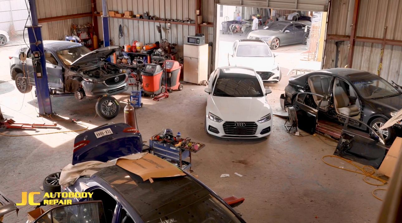A garage filled with lots of cars being repaired.