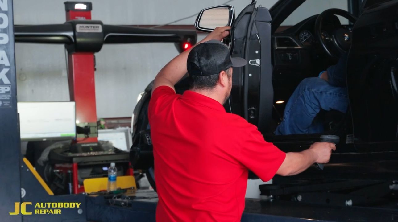A man in a red shirt is working on a car