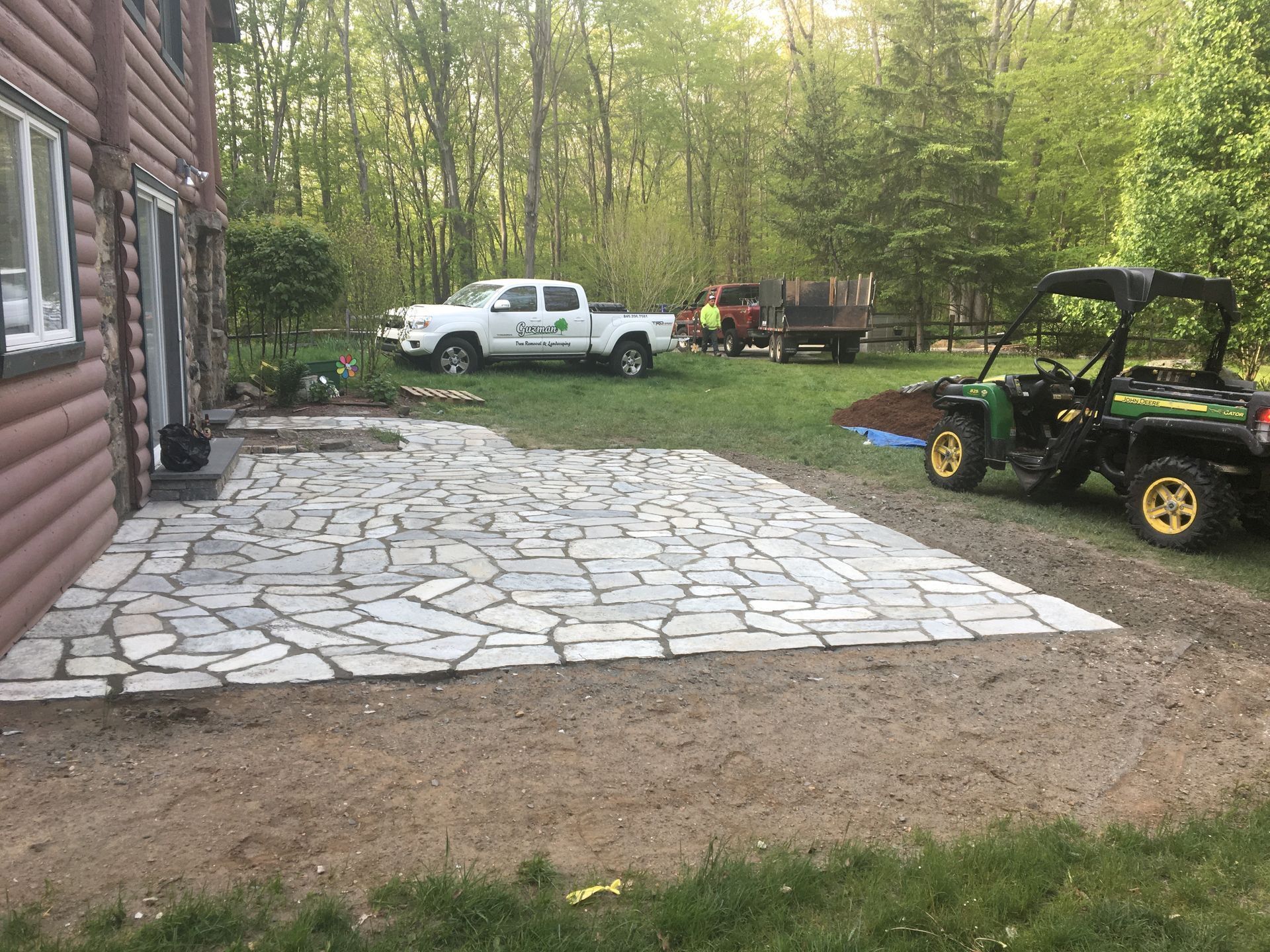 A john deere gator is parked in front of a stone patio