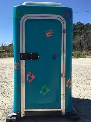 Blue portable toilet with colorful handprints on the door, outdoors in a sunny open area