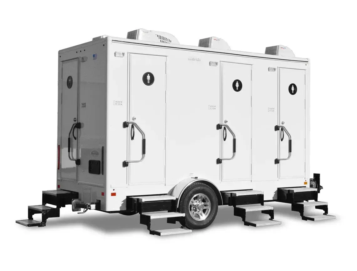 White portable trailer with three connected units and wheels on a plain background