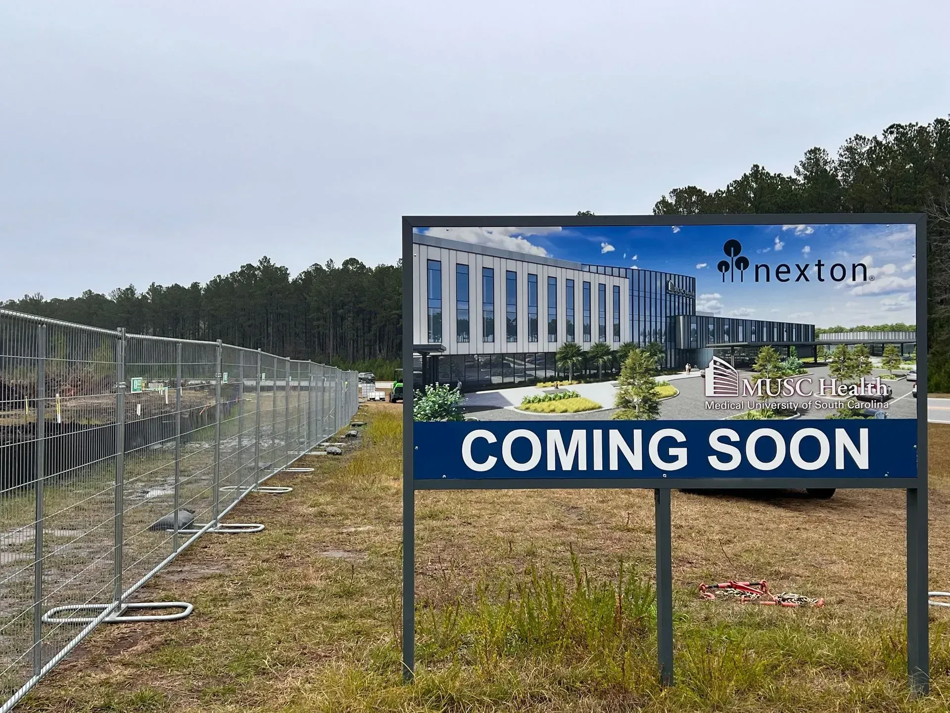 Roadside “Coming Soon” sign for Nexton development near fenced construction site
