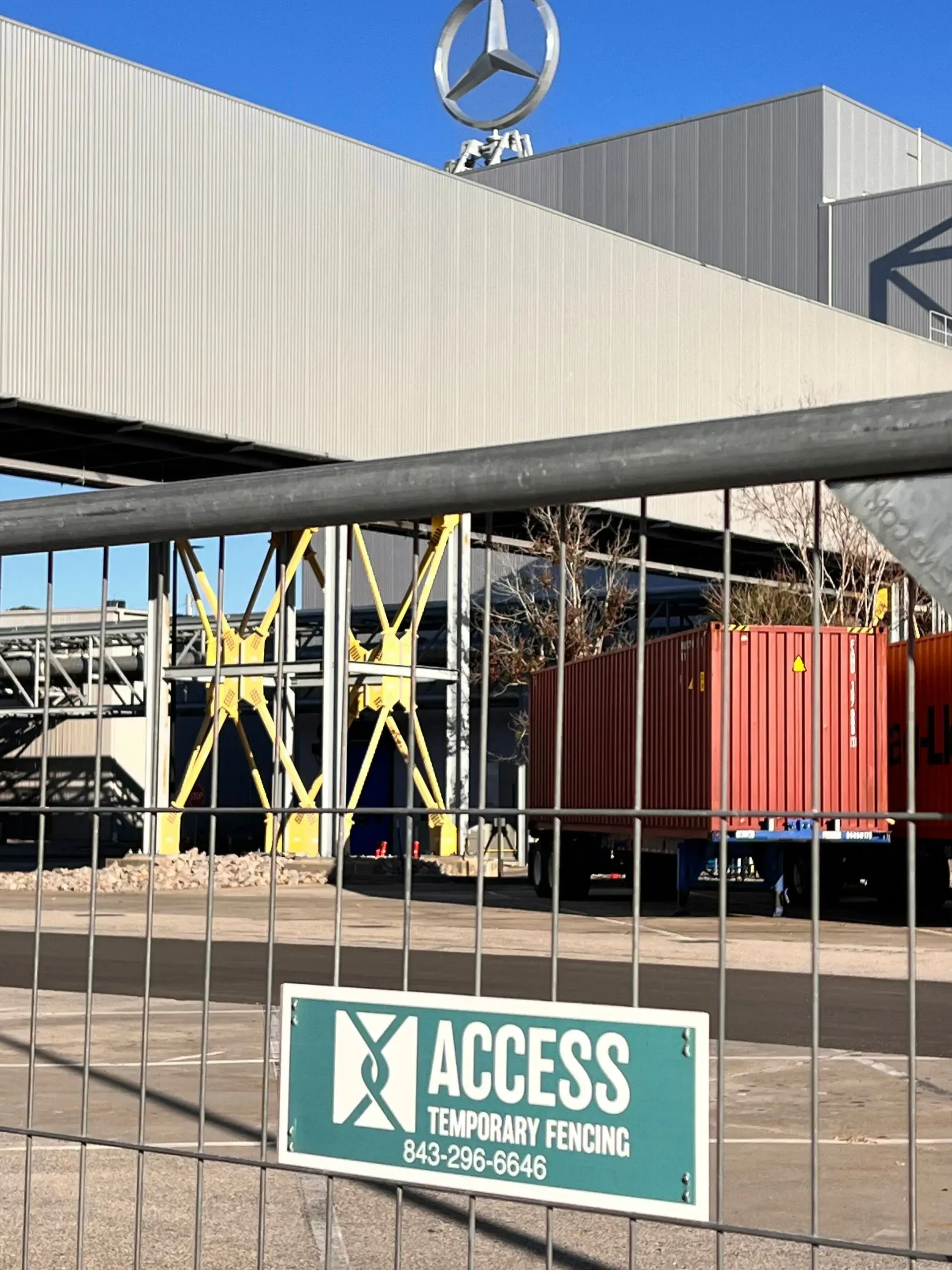 Mercedes-Benz factory yard behind a fence with a green 