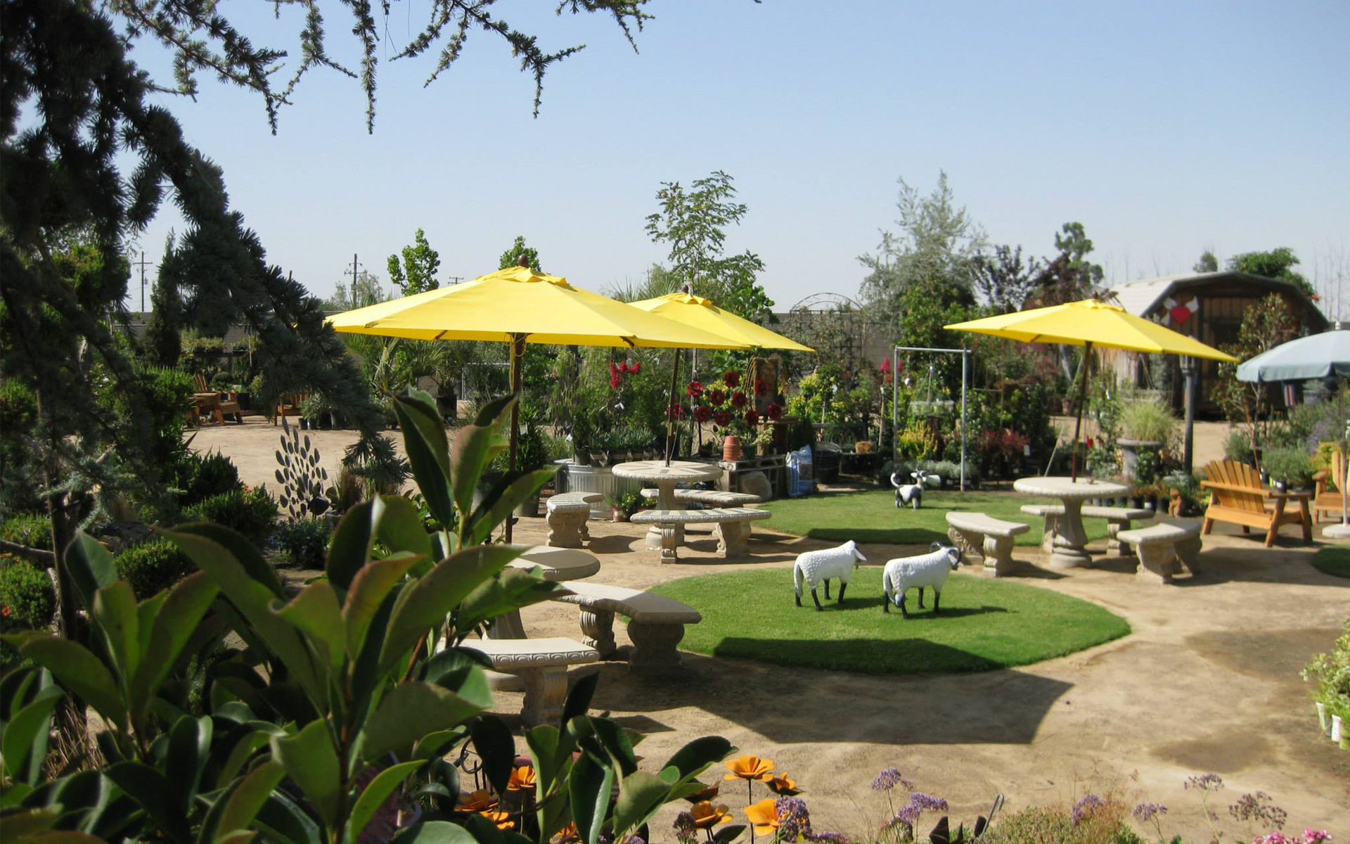A picnic area with tables and umbrellas in a garden