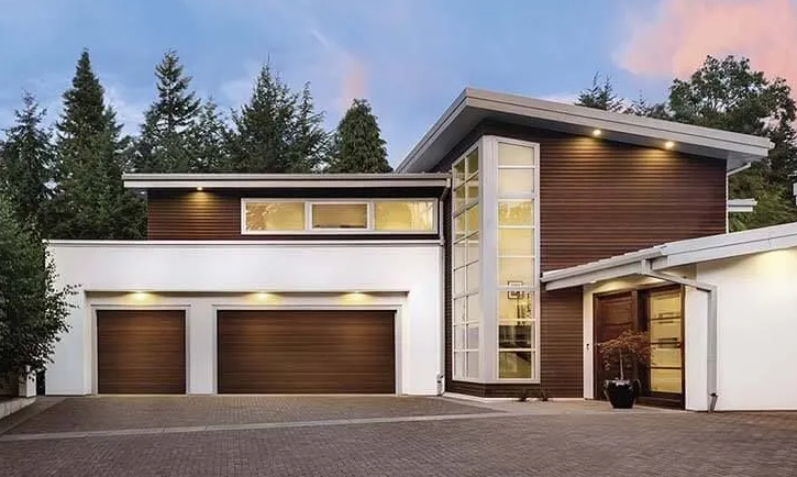 Modern home exterior with white and brown siding, two-car garage, and a paved driveway.