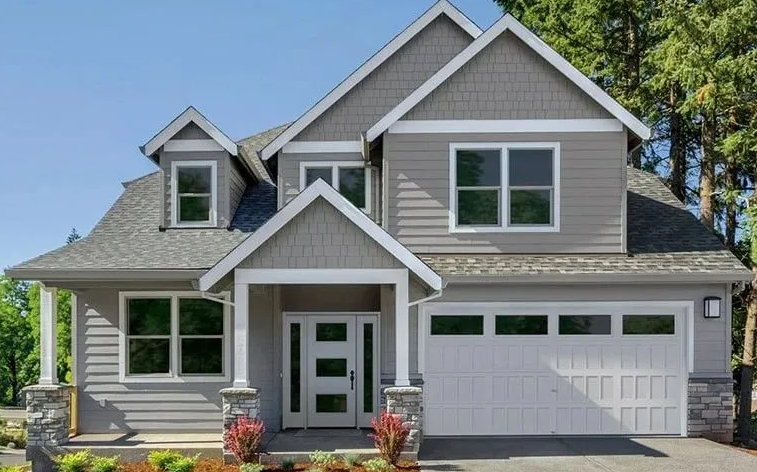 Gray two-story house with white trim, garage, front door, and dormers. Blue sky and trees in the background.