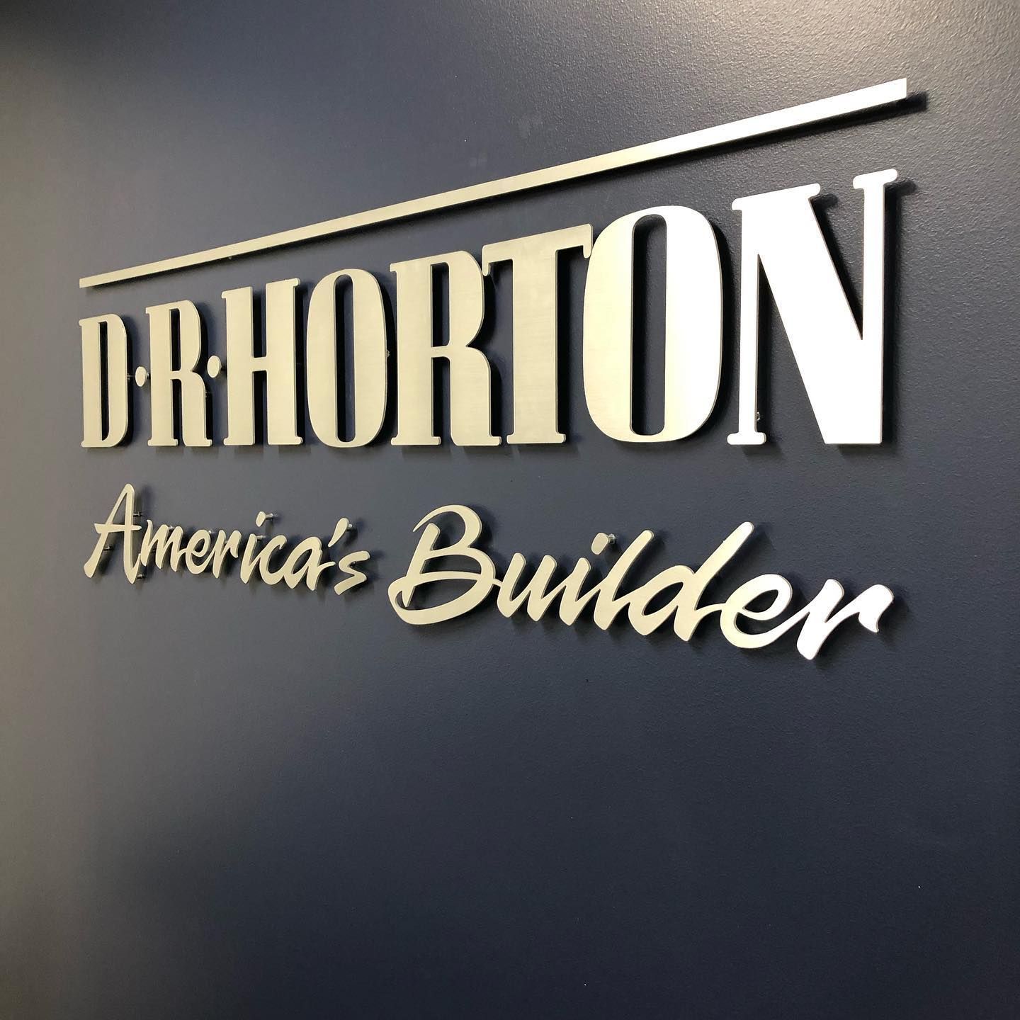 D.R. Horton logo on a blue wall: silver text 