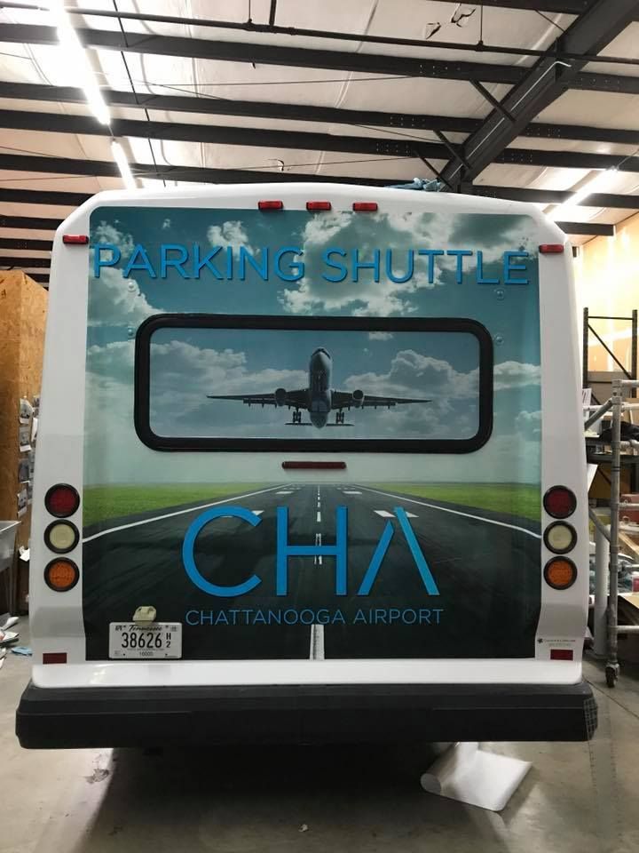 Rear view of a white airport shuttle bus with 