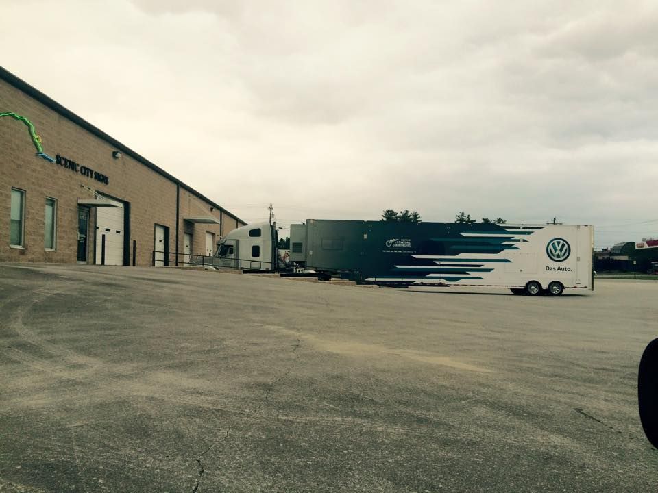 Large building with loading docks, parked semi-truck, and trailer on overcast day.