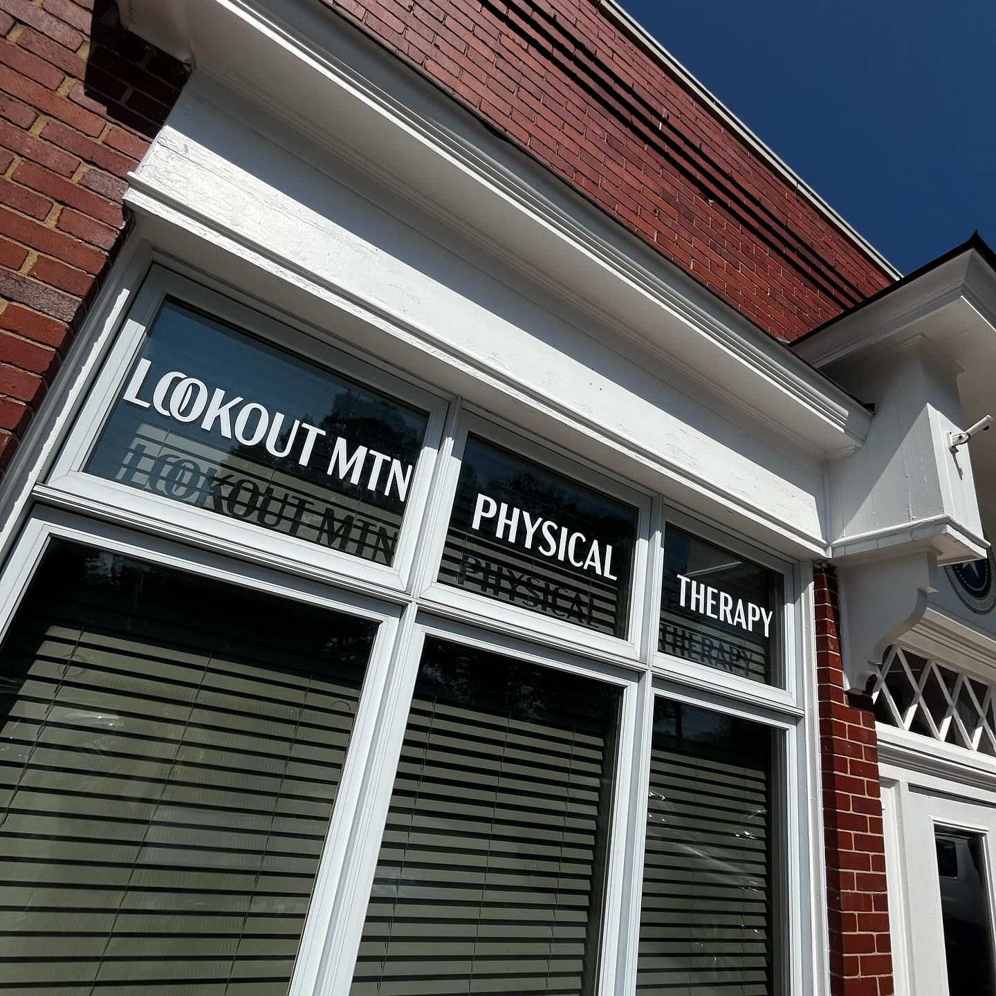 Lookout Mountain Physical Therapy sign on a brick building with white trim and blinds.
