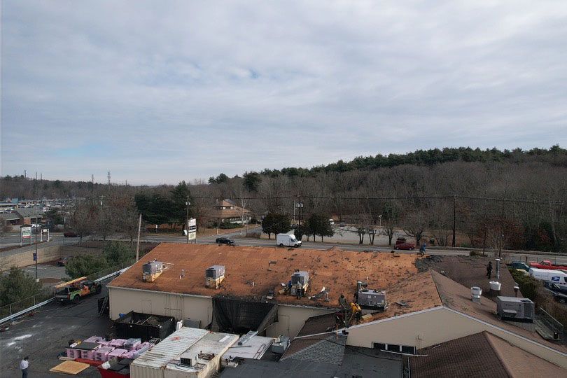 An aerial view of a building with a roof that is being repaired