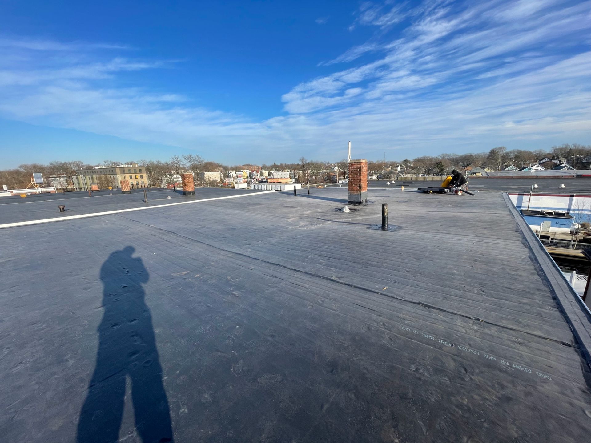 A shadow of a person is cast on the roof of a building