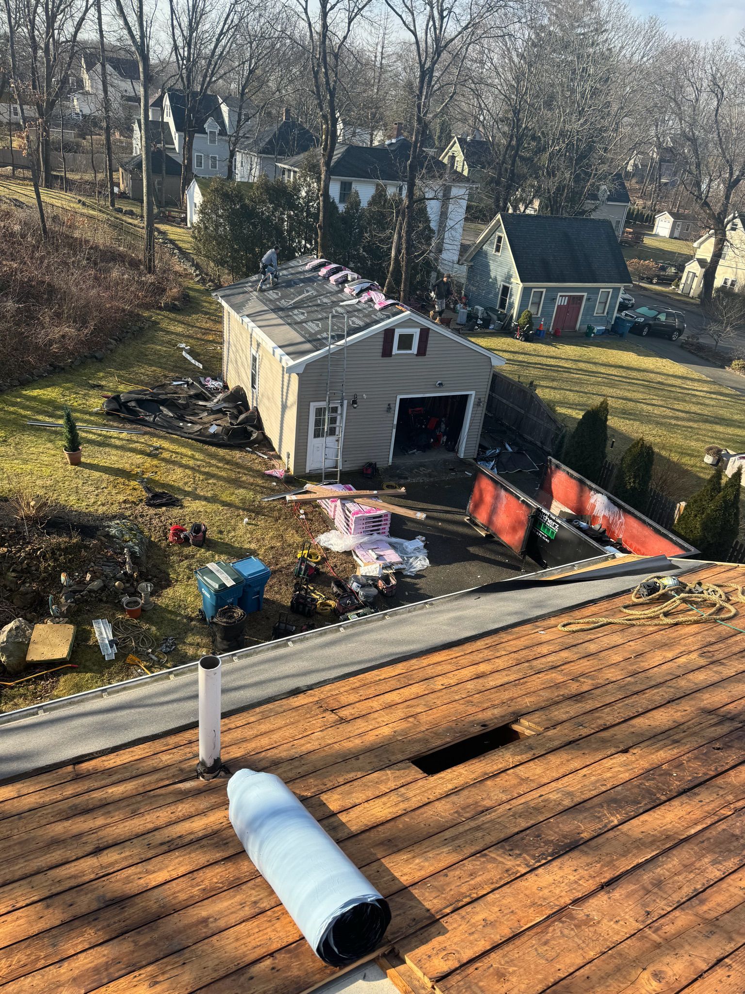An aerial view of a roof with a garage in the background