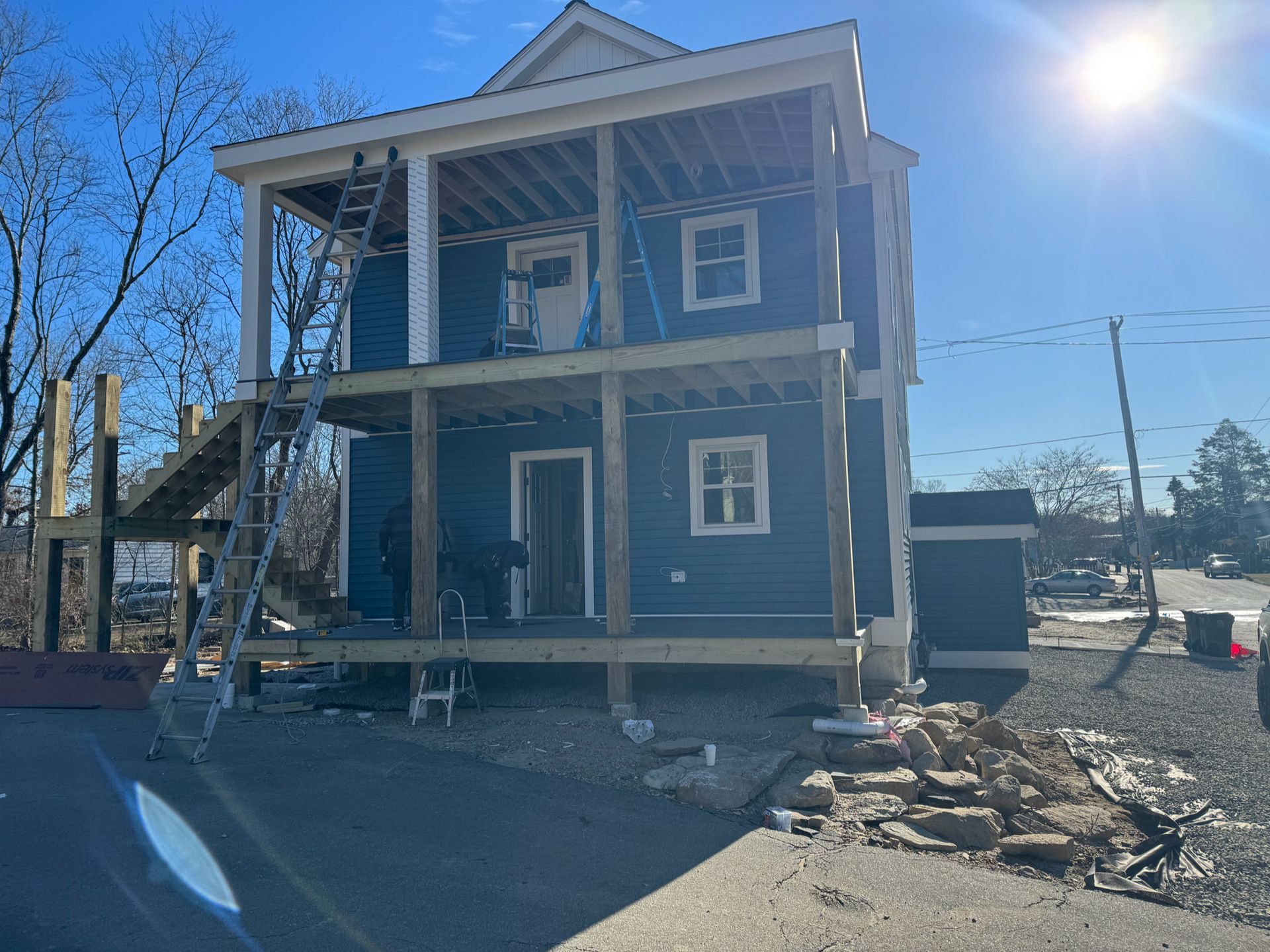 A blue house is being built on stilts on a sunny day