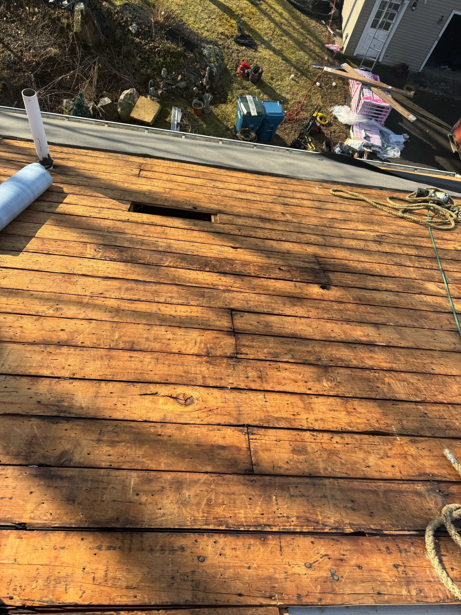 A wooden roof with a hole in it is being repaired