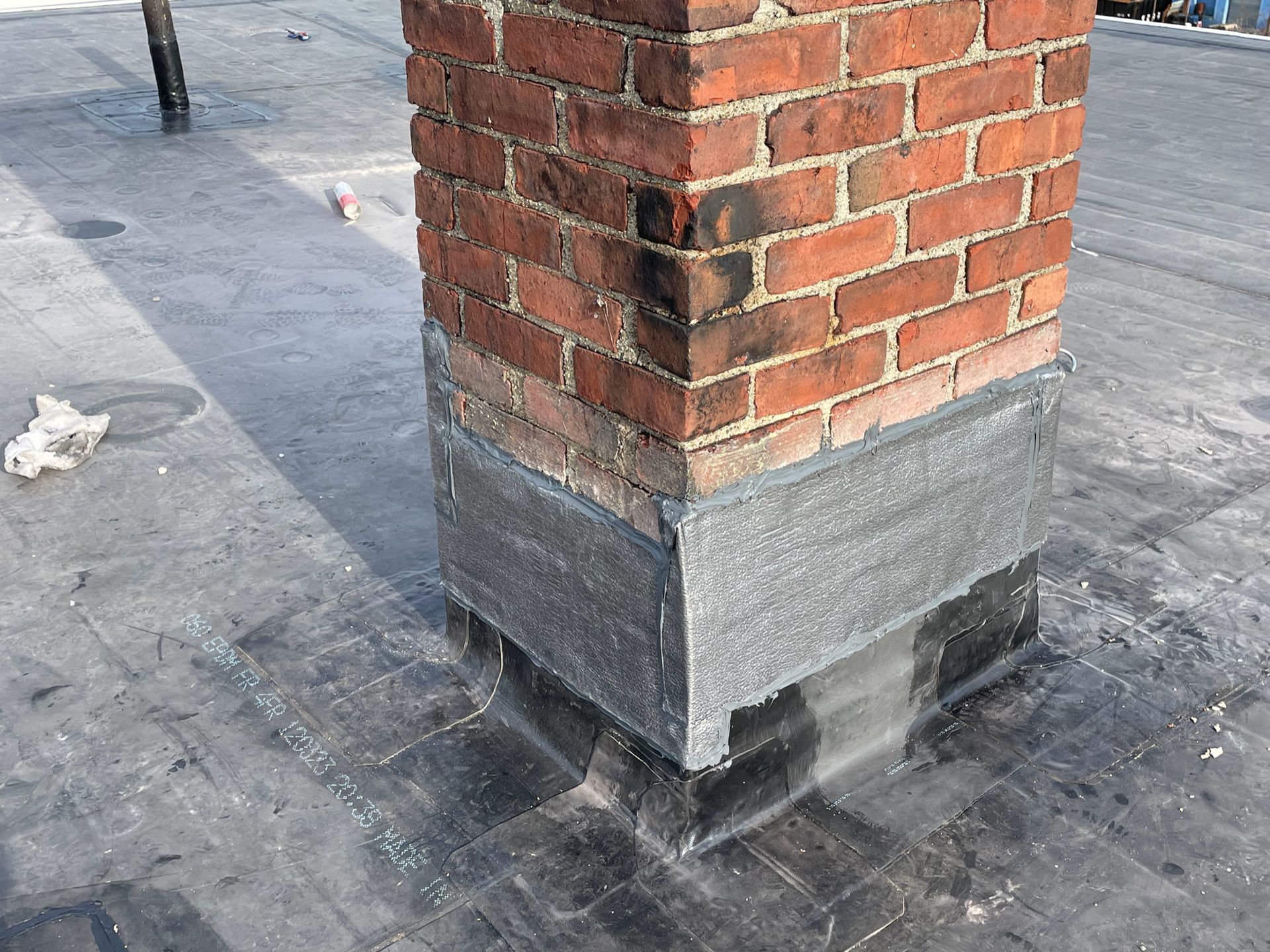 A brick chimney is sitting on top of a roof