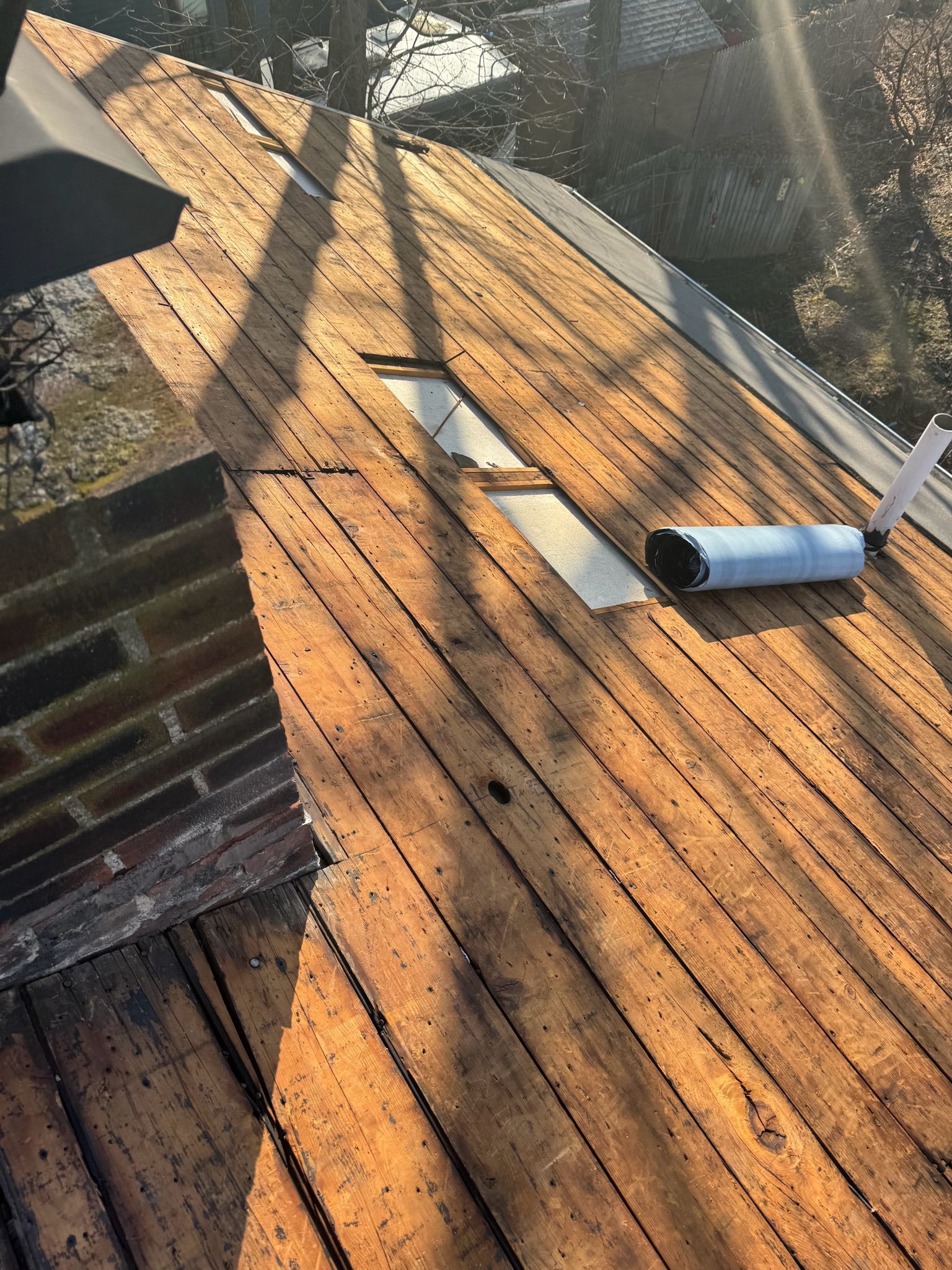A wooden roof with a brick chimney in the background