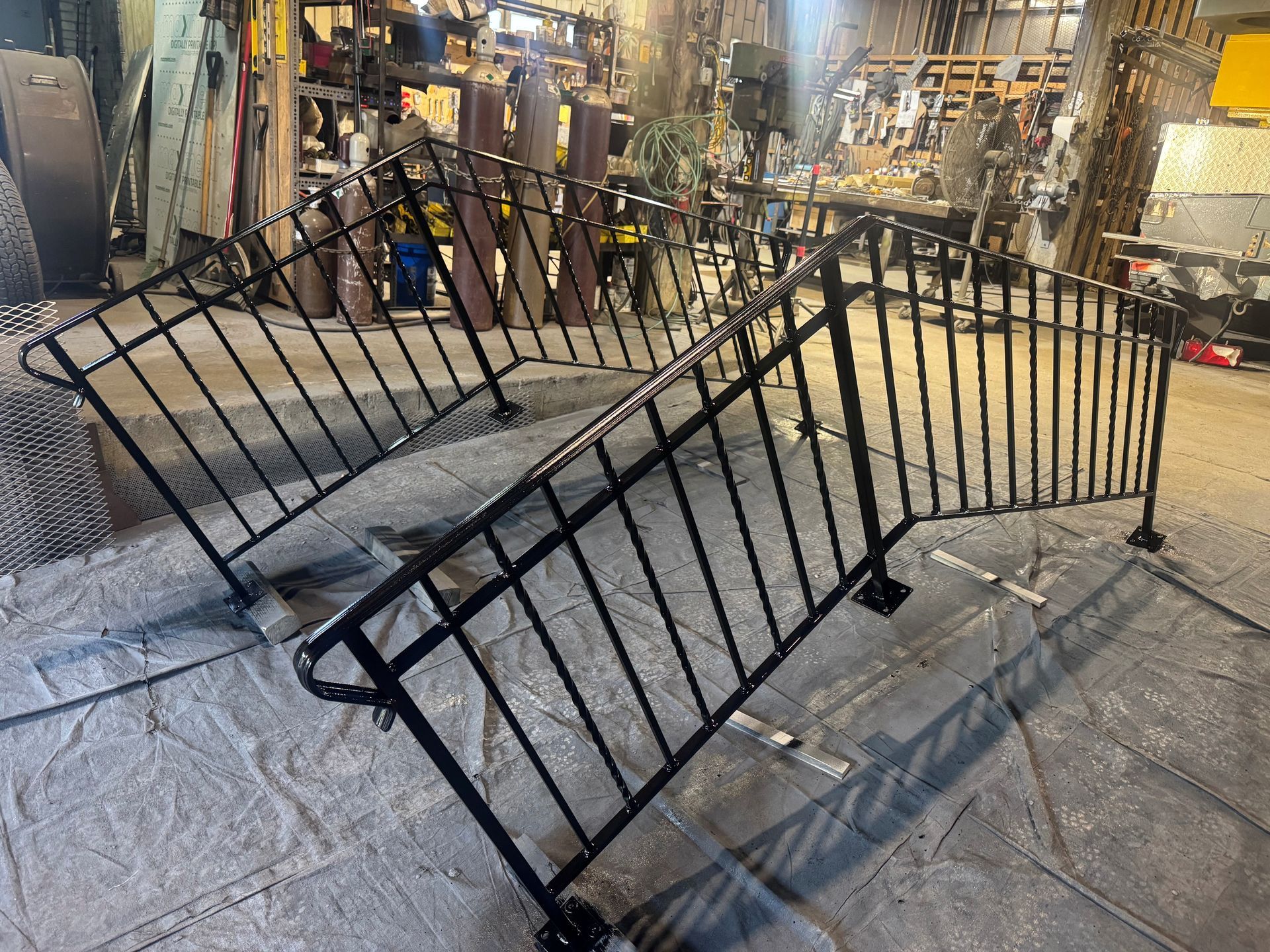 Broken black metal barricade lying across a stone floor inside a lit shop or market.