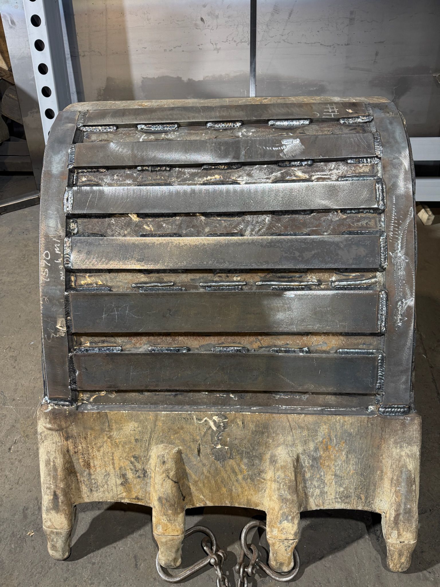Rusty industrial metal vent with horizontal slats and a dirty beige base on a shelf