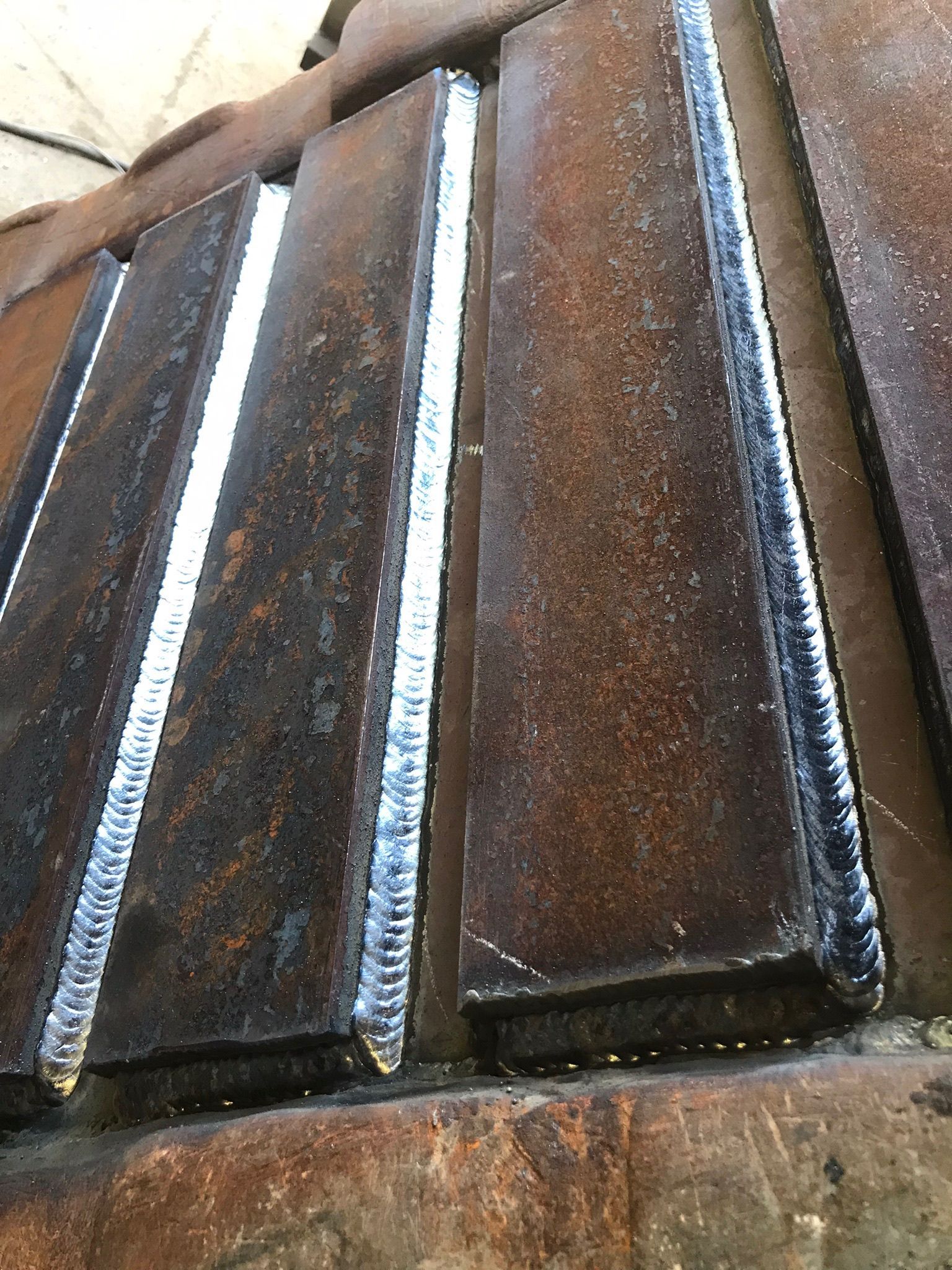 Close-up of weathered dark wooden stairs with worn edges and a rusty metal railing