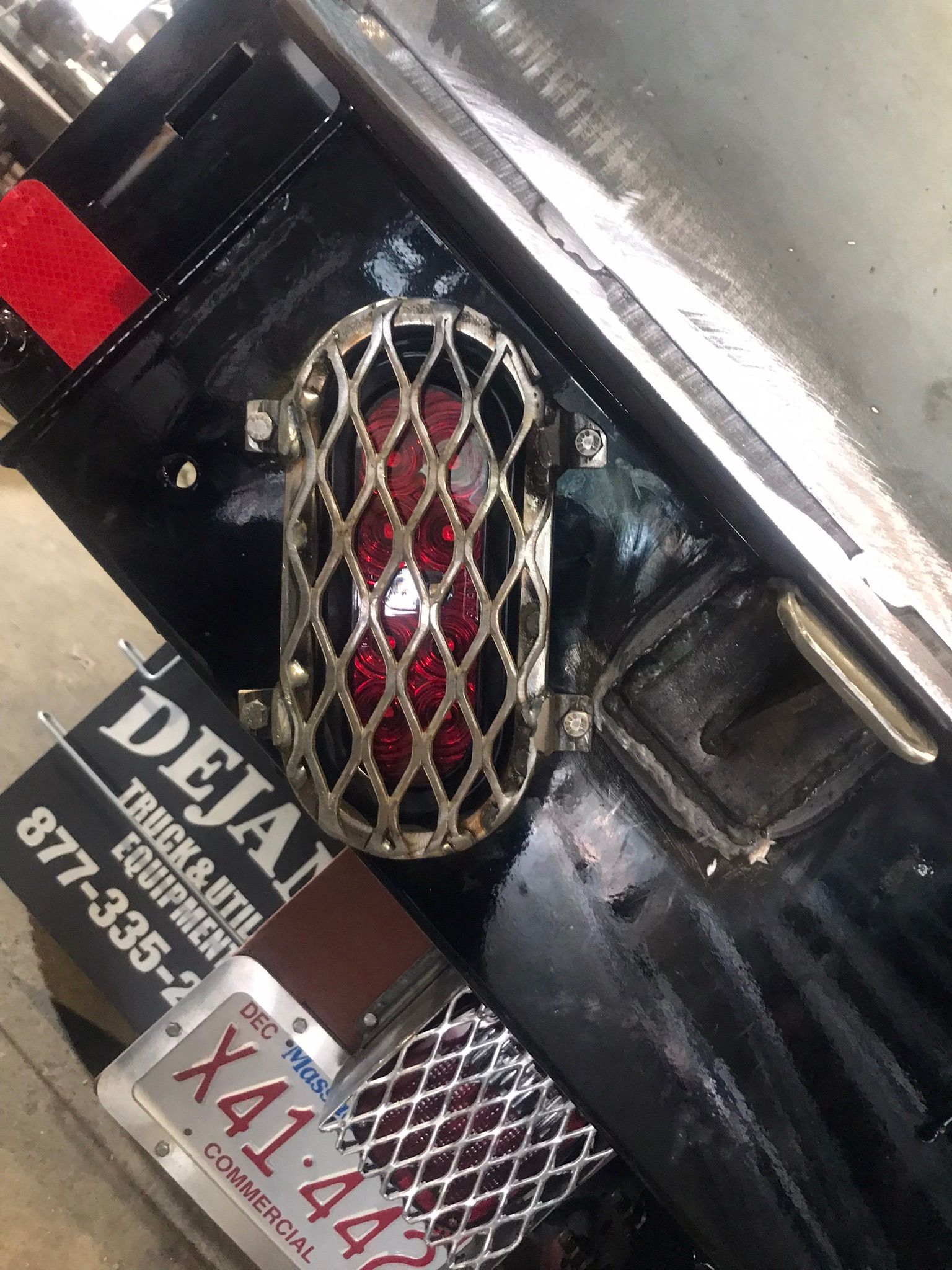 Close-up of a black and chrome industrial machine with a red-lit grille and labels.