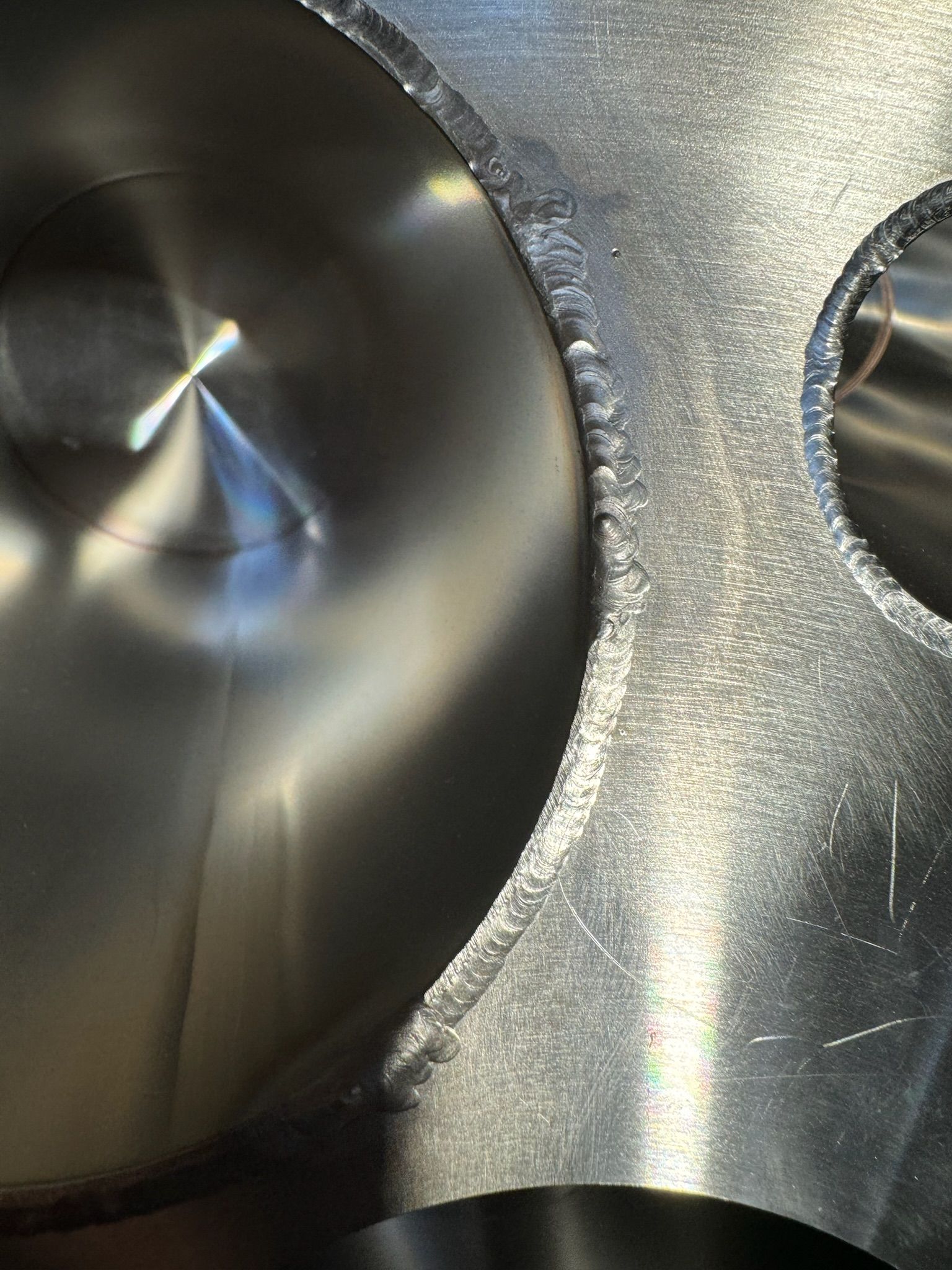 Close-up of a metallic surface with two circular openings and brushed silver texture