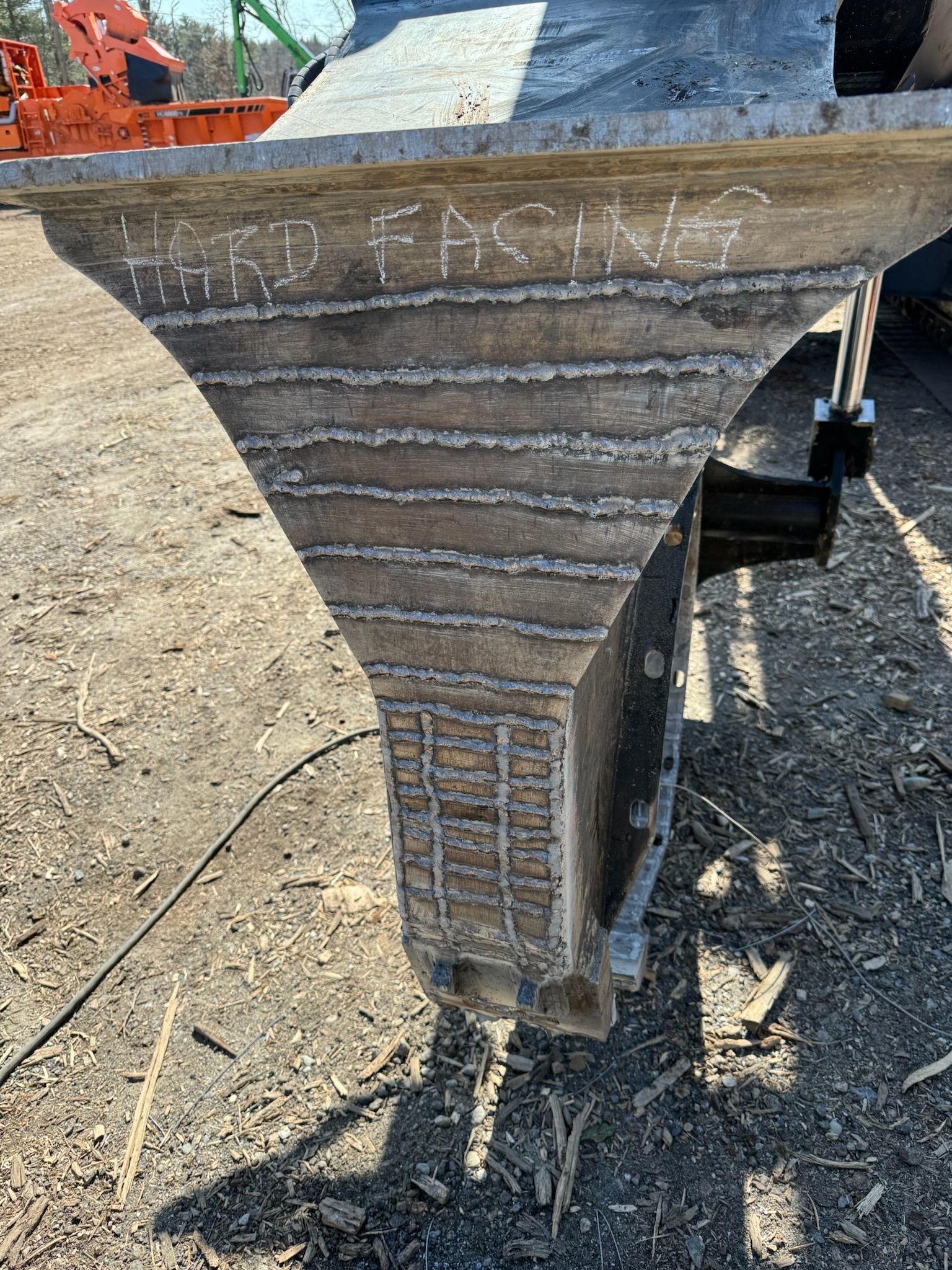 Worn concrete pier cap at a construction site, with chalk markings and stacked materials nearby