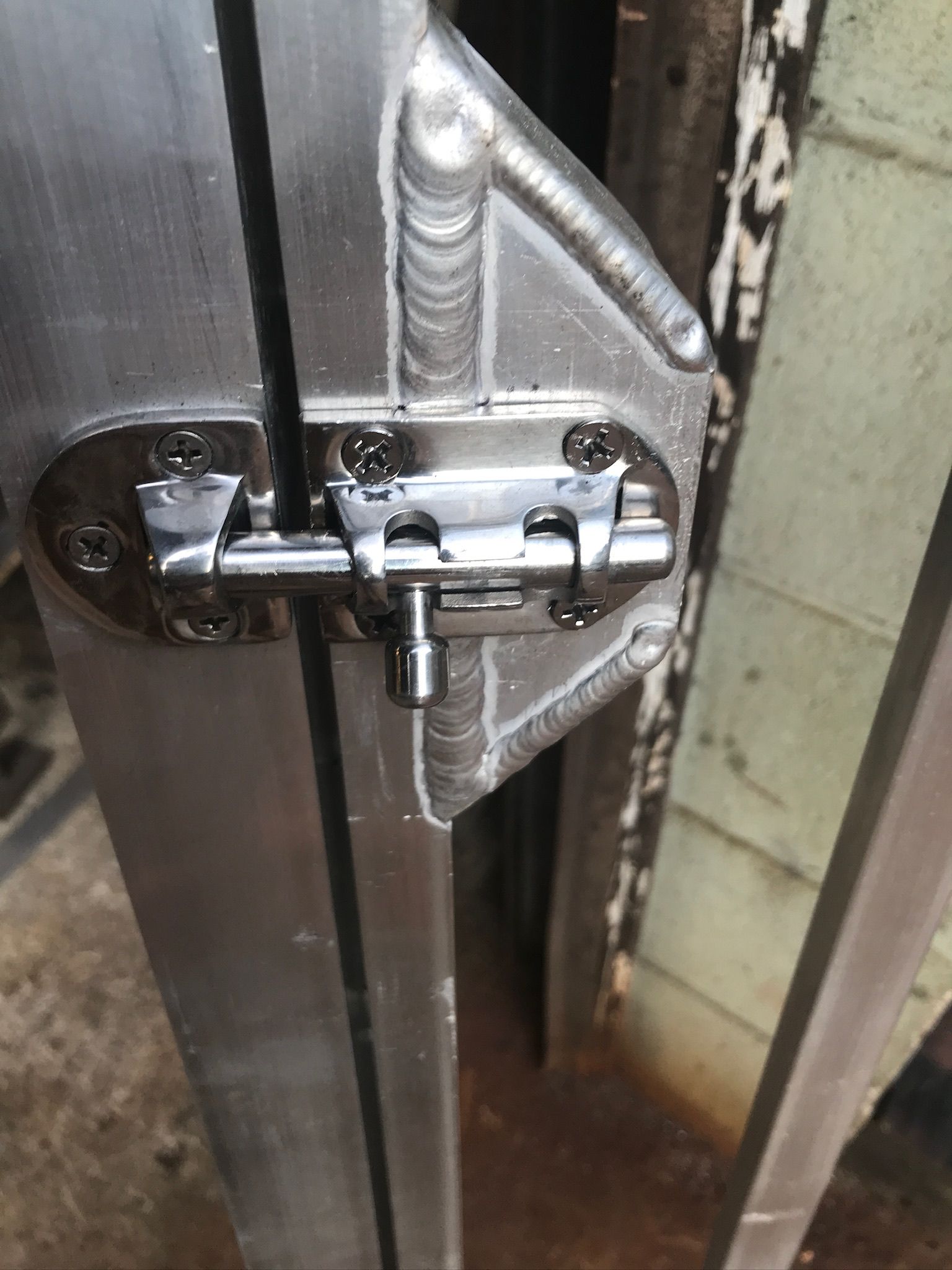 Close-up of a metal sliding door latch and bolt on a gate