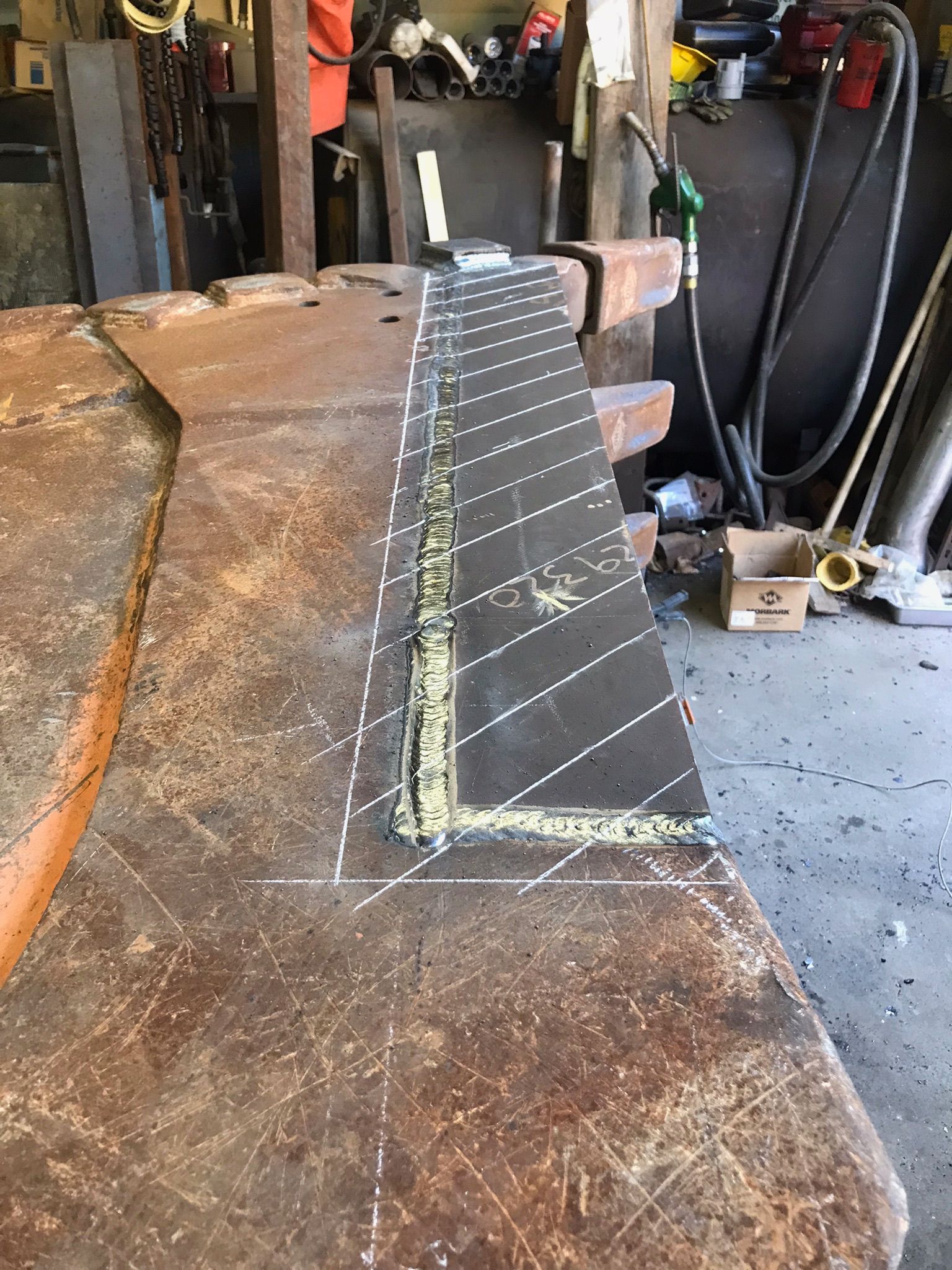 Black fabric ramp with reflective strips on a worn workbench in a workshop