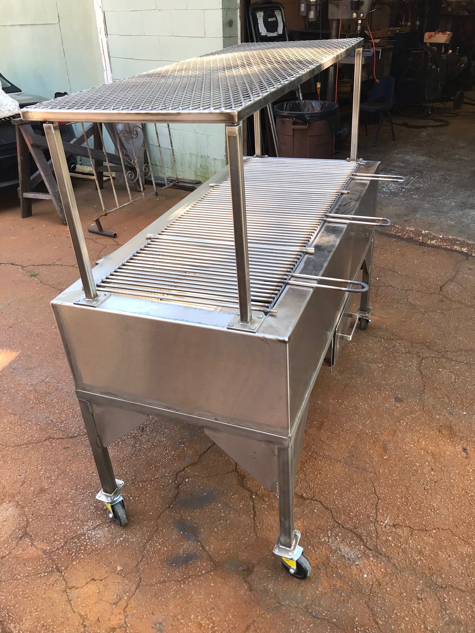 Stainless steel food cart with slotted trays and a raised canopy on casters outdoors