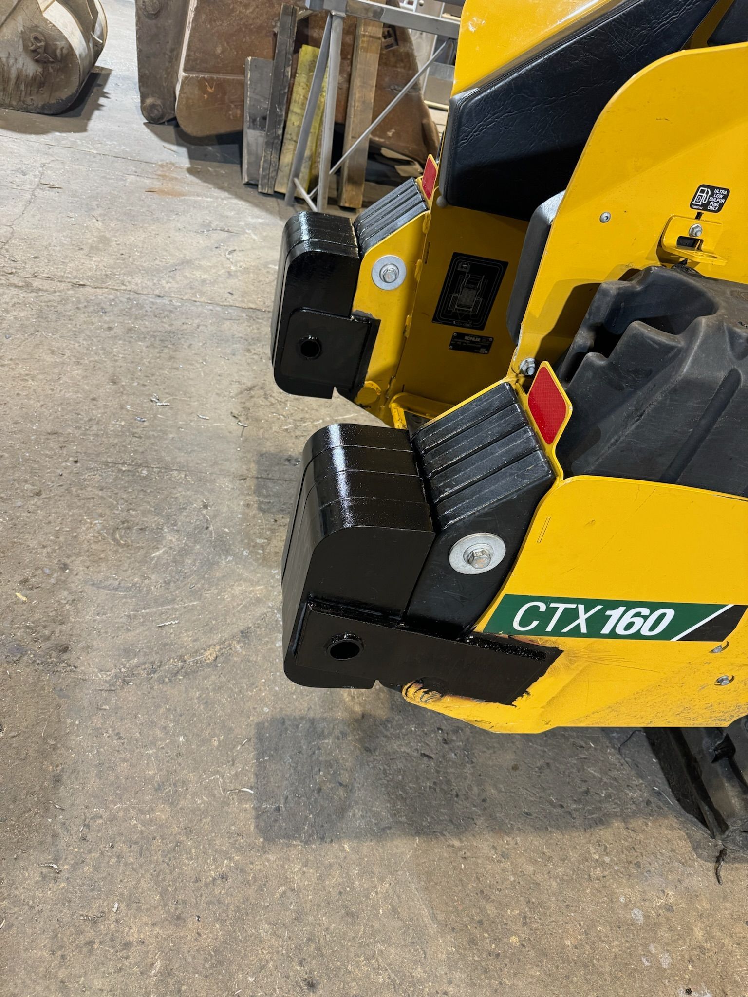 Yellow construction machine close-up with black hydraulic parts and a green CTX160 label.