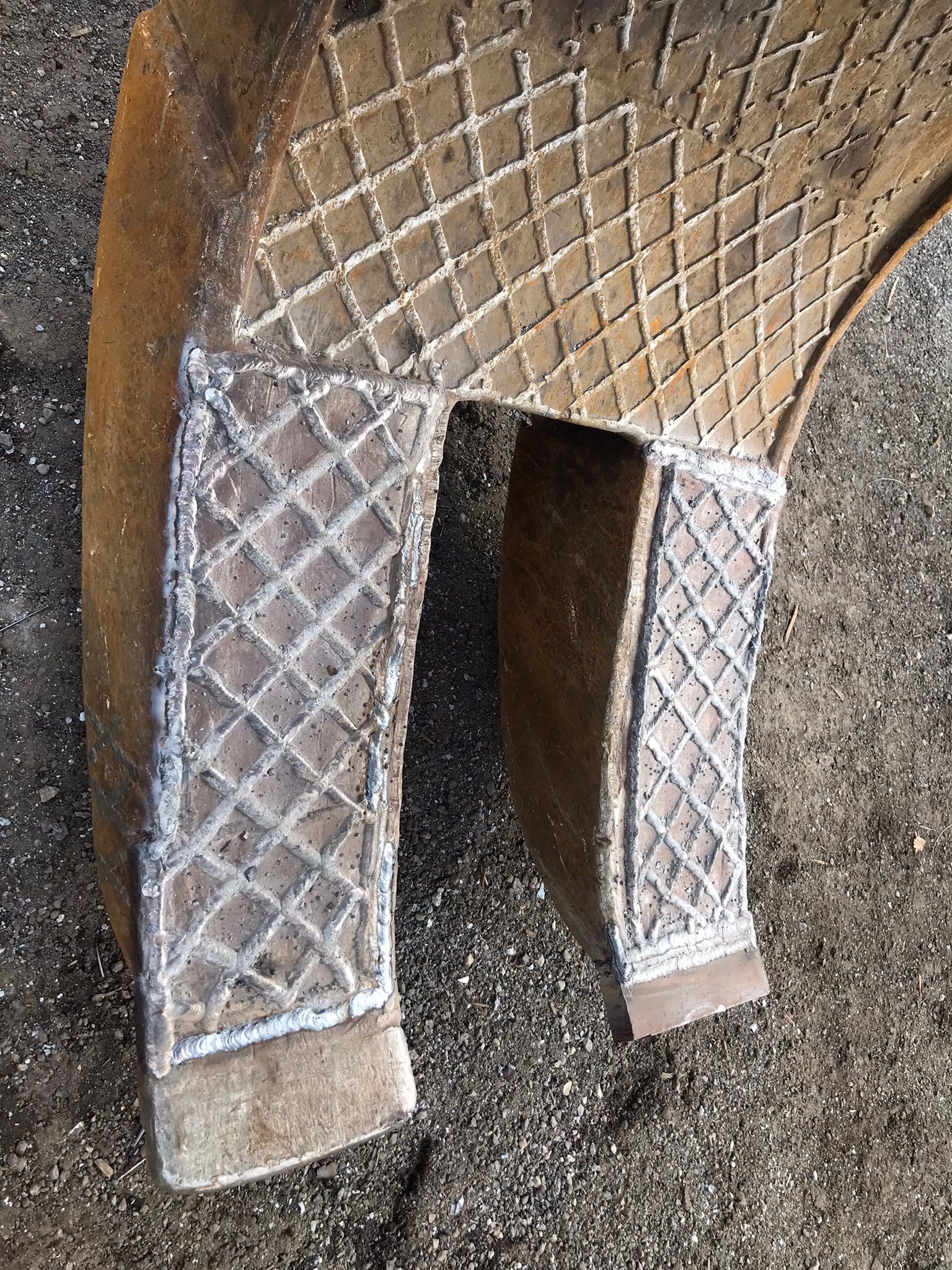 Quilted tan pet hammock with a U-shaped opening, hanging against a wall.