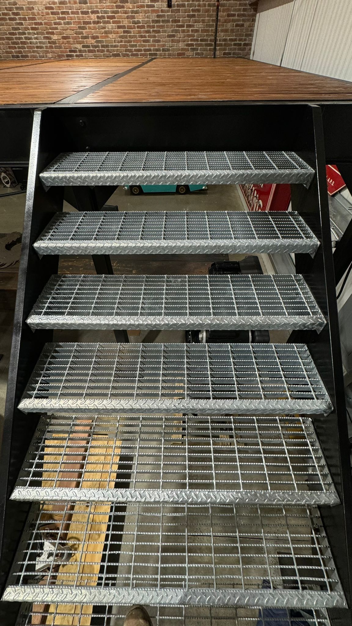 Metal shelving unit with empty wire racks and a few boxes in an industrial storage area