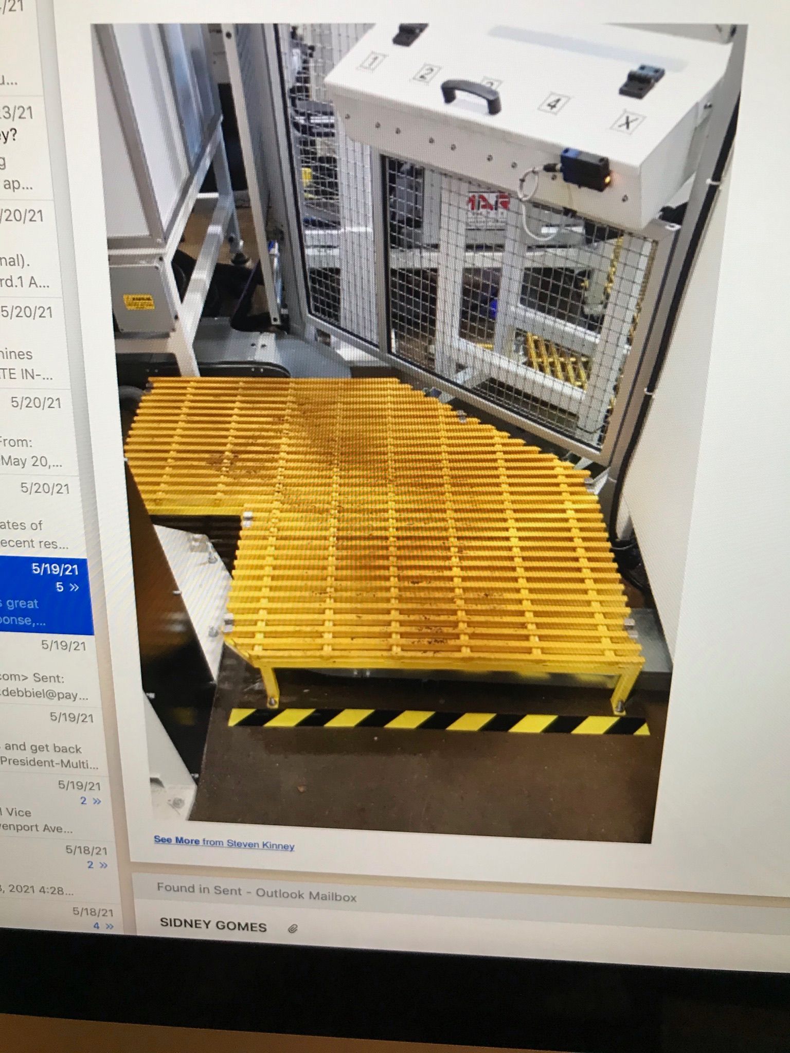 Yellow grated ramp with black hazard stripes in an industrial machine area