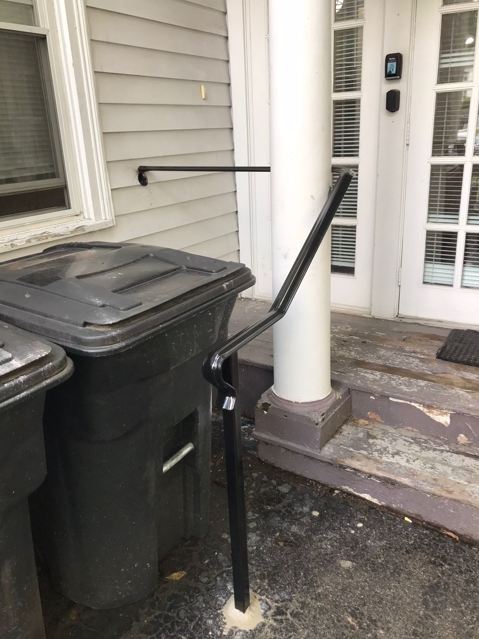 Accessible handrail beside front steps leading to a house entrance
