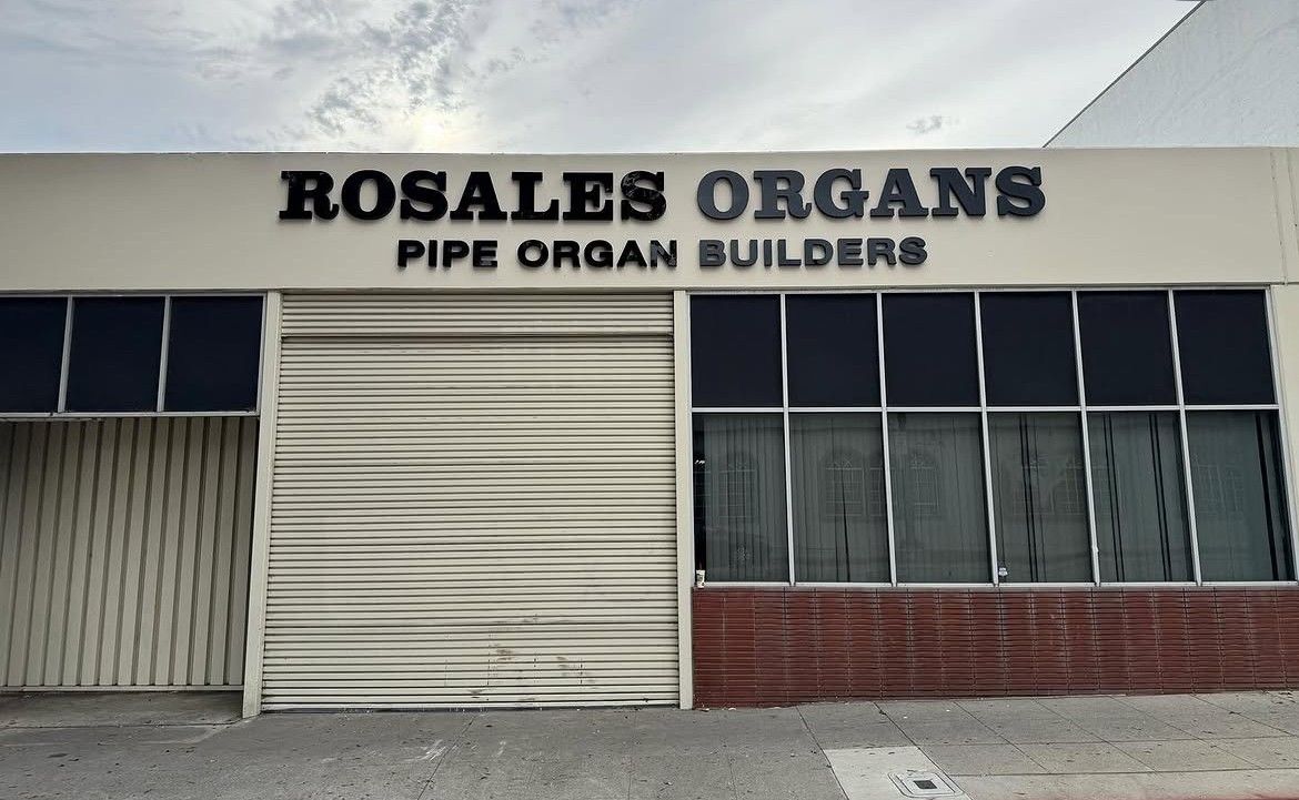 Rosales Organs storefront with “Pipe Organ Builders” sign on a white and brick building