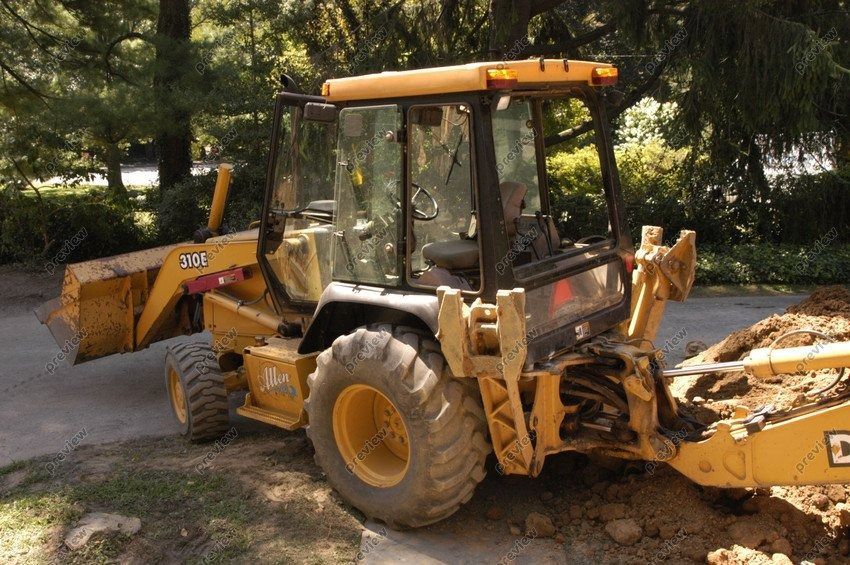 A yellow tractor is parked on the side of a road