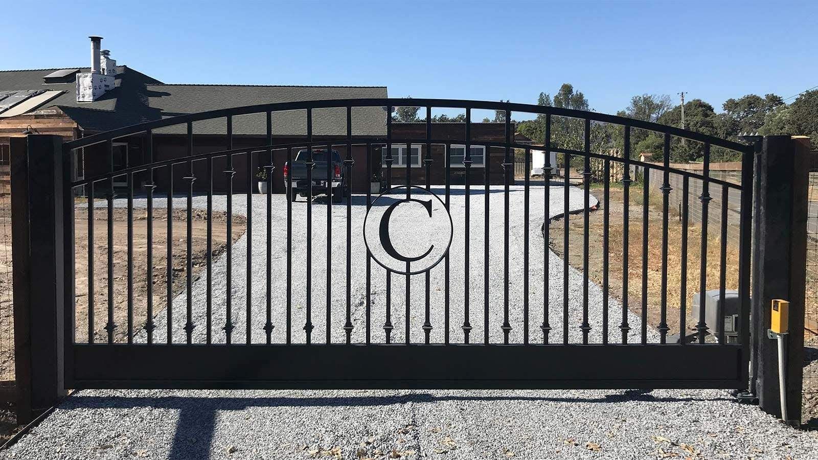 Black metal driveway gate with the letter 