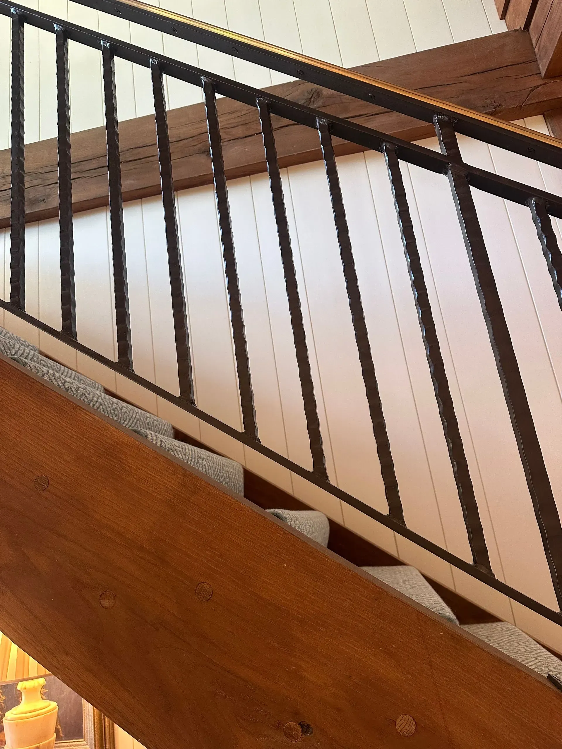 Wooden staircase with black metal railing.