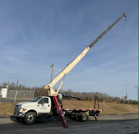 Yellow crane at a construction site lifting materials; building frame in the background.