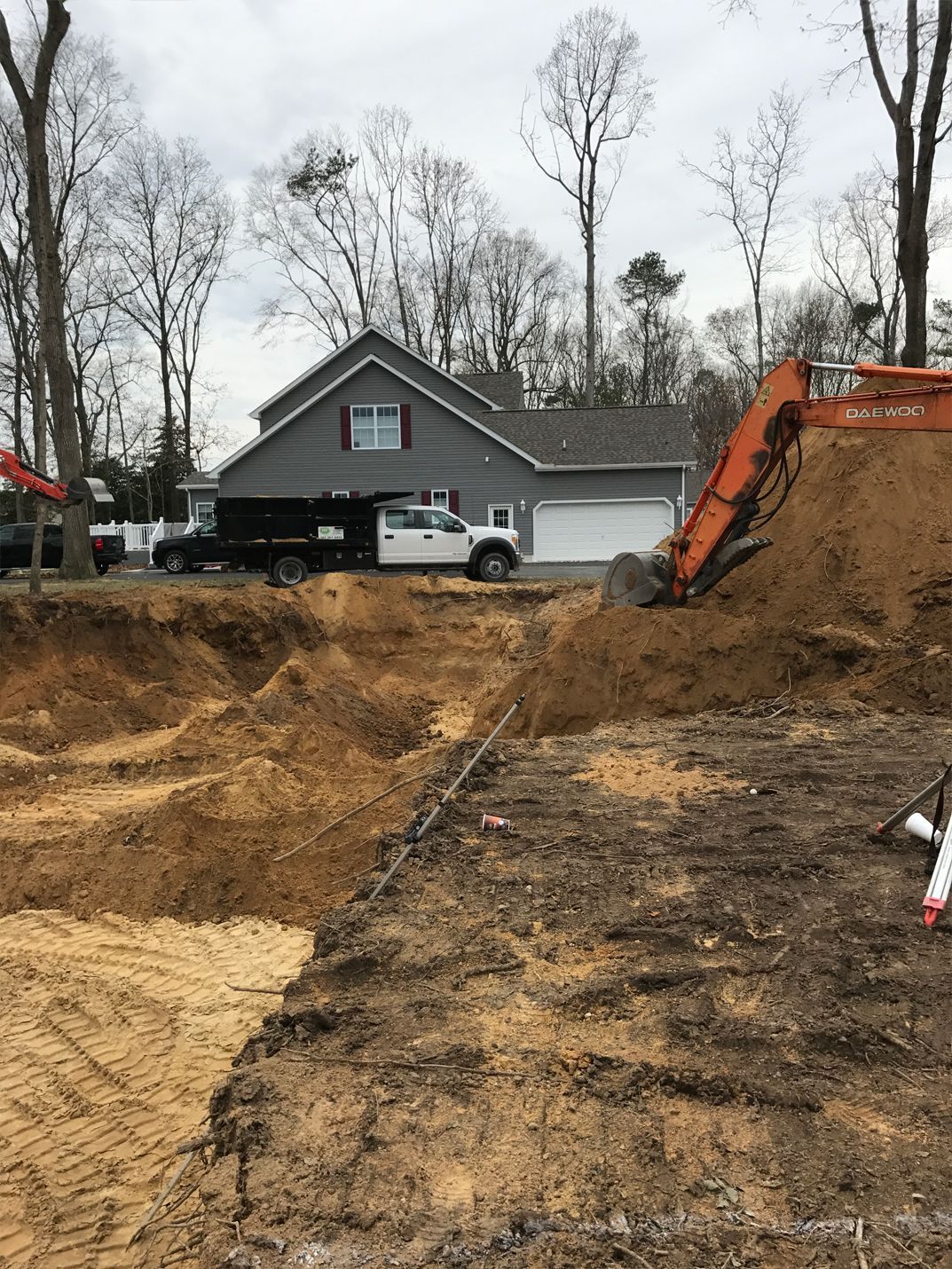 A large pile of dirt is sitting in front of a house.