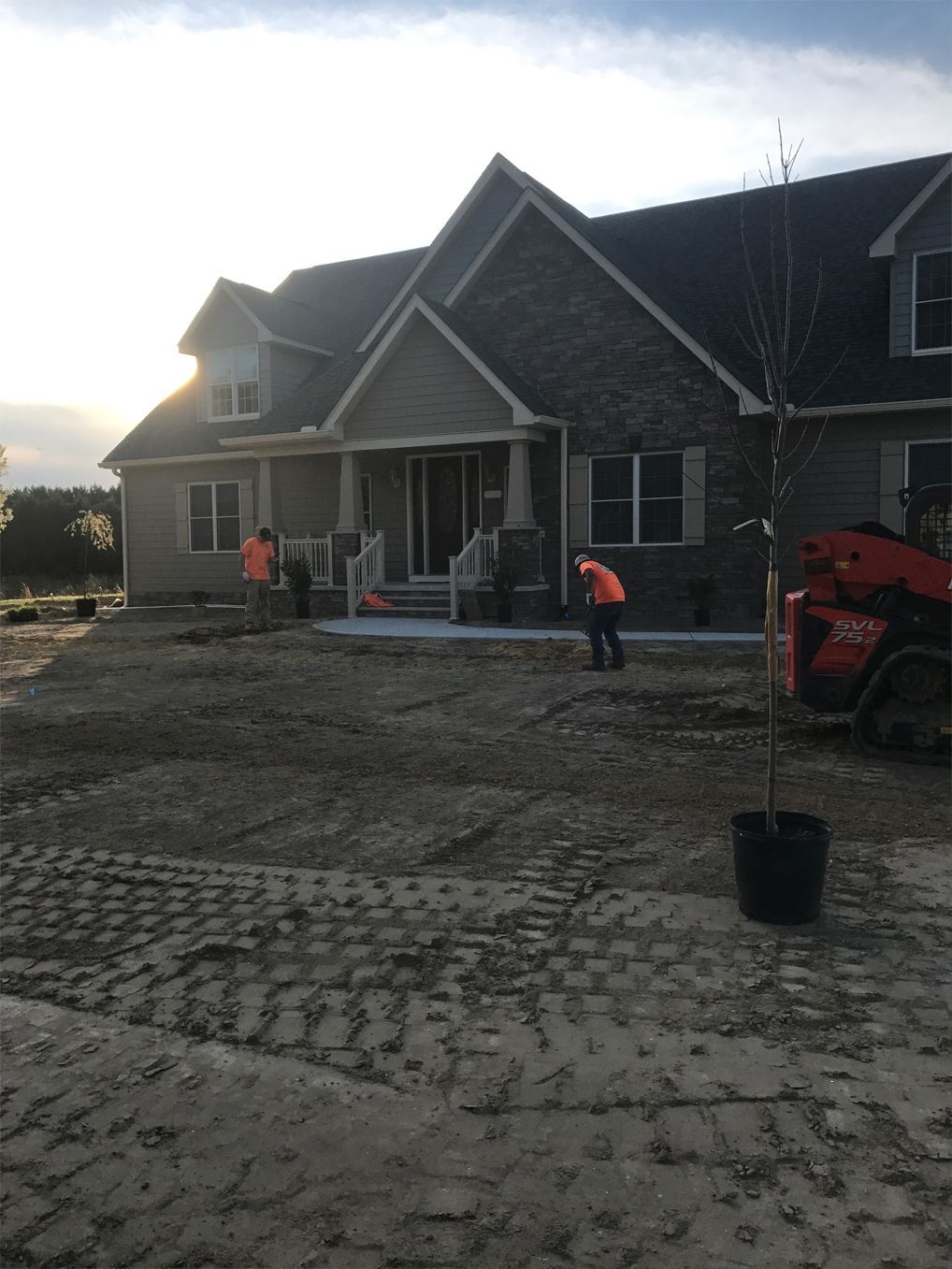 A large brick house with a lot of dirt in front of it