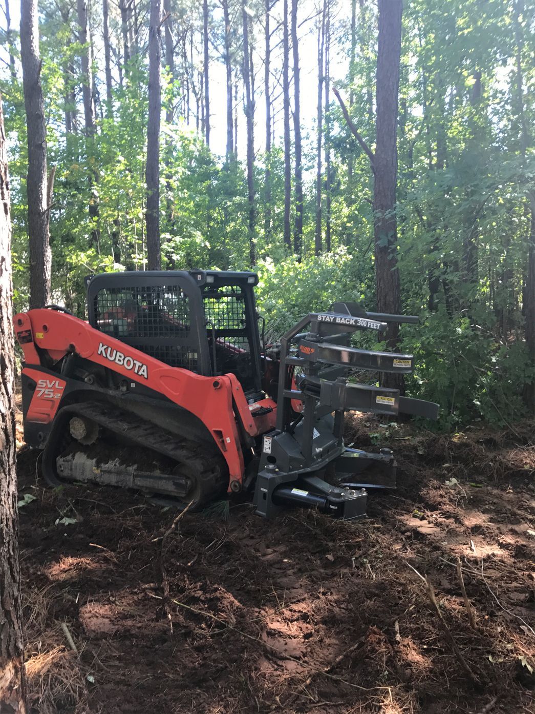 A bulldozer is sitting in the middle of a forest.