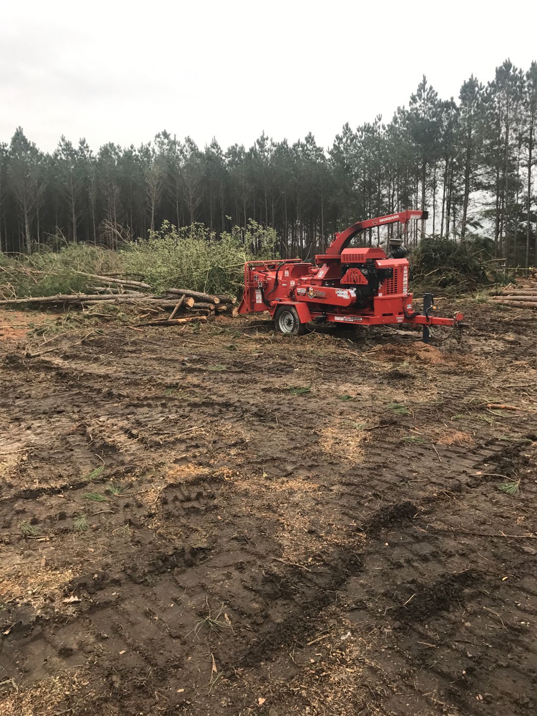 A red machine is sitting in the middle of a dirt field.