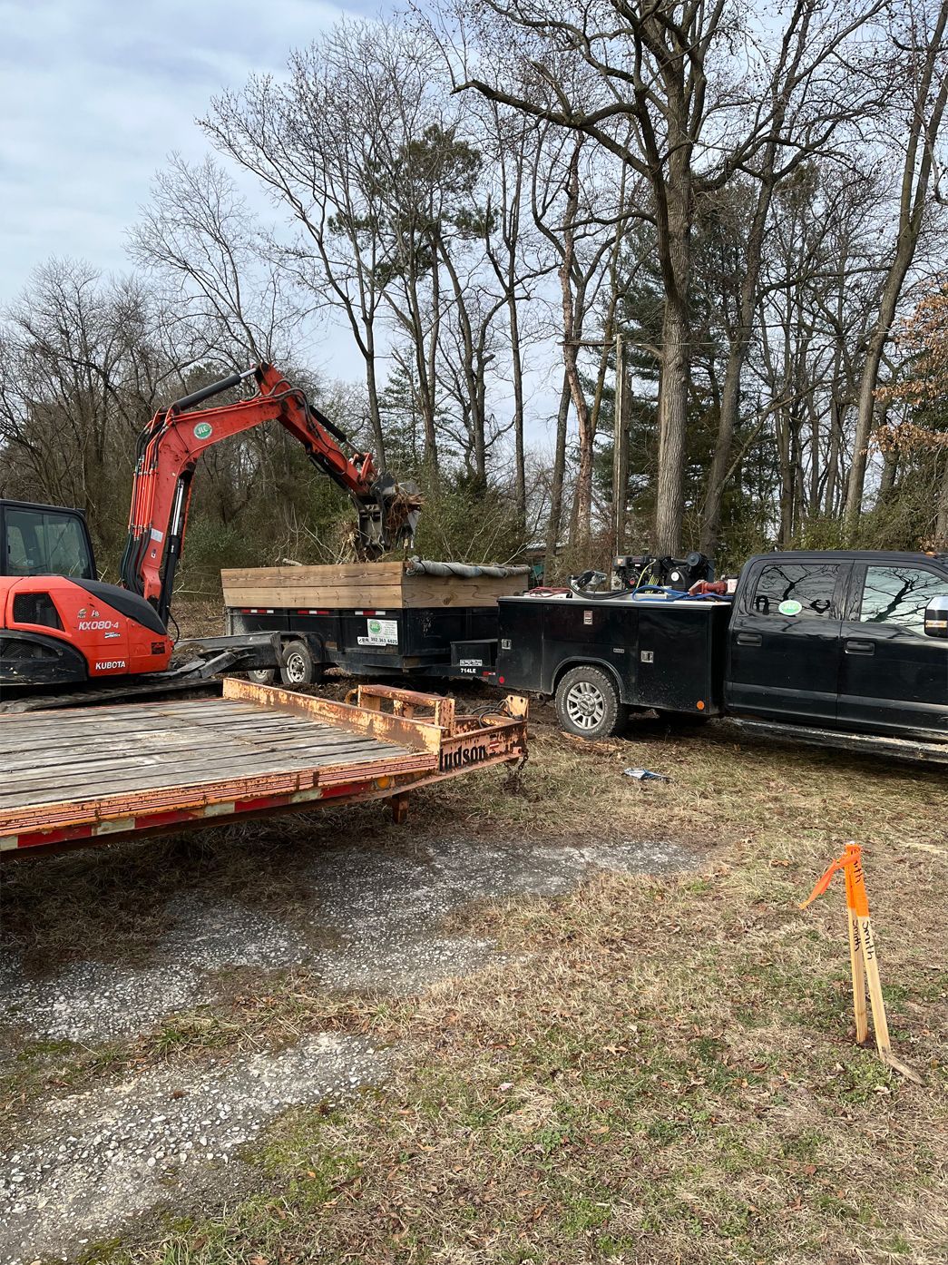 A truck is being towed by an excavator on a trailer.