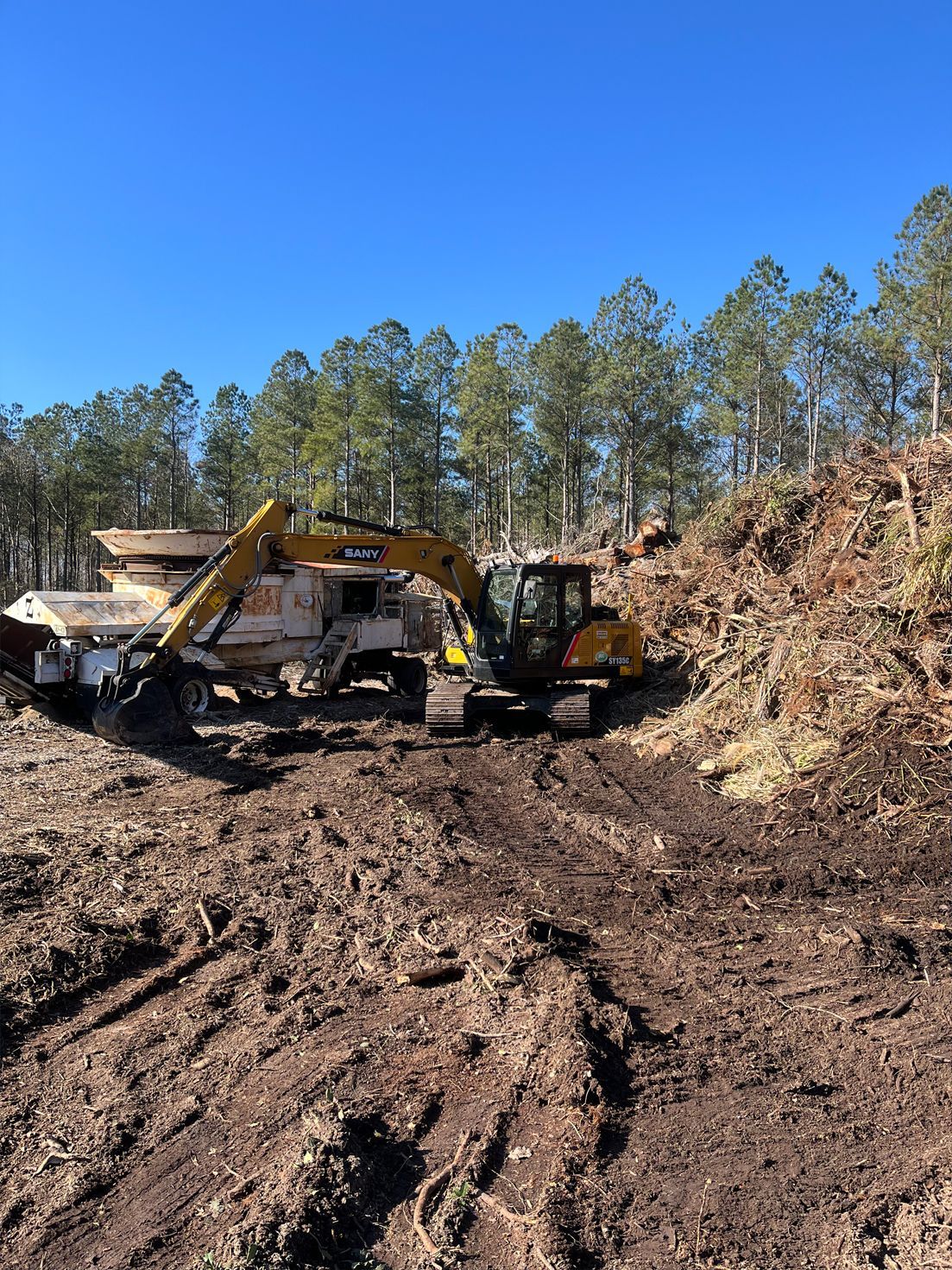 A bulldozer and a dump truck are working on a dirt road.