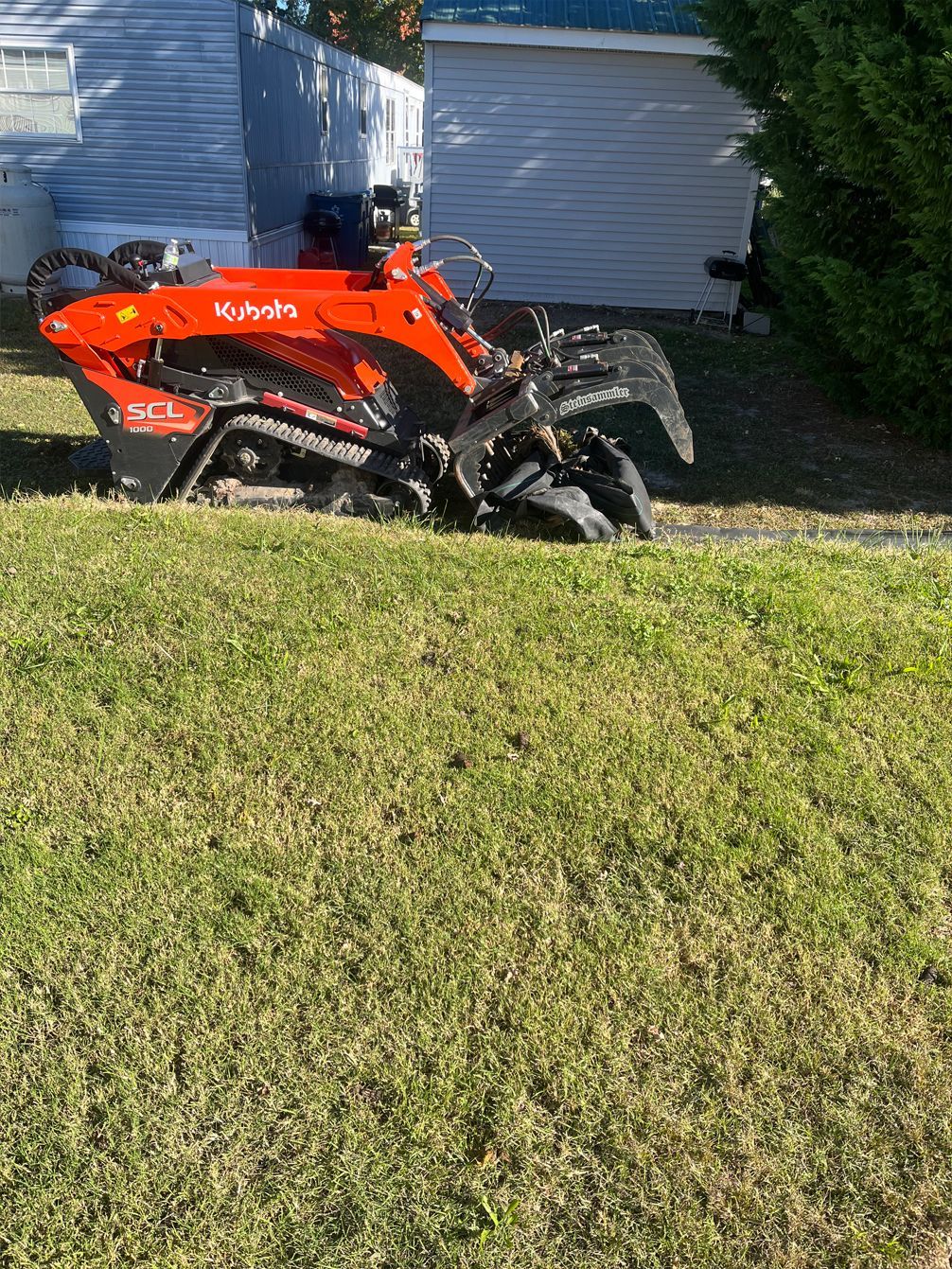A lawn mower is sitting on top of a lush green lawn.
