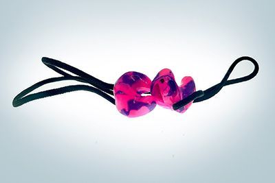 A pair of pink and purple ear plugs on a black string