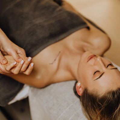 A woman is laying on a bed getting a acupuncture treatment.